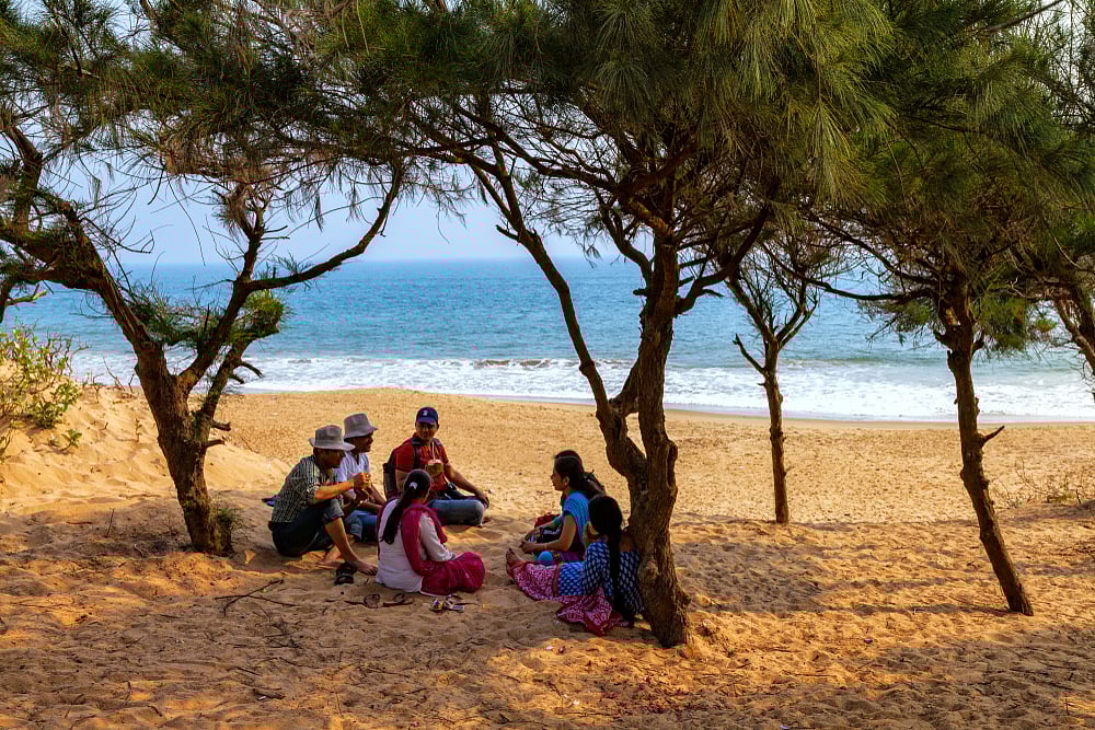 A family enjoying a leisurely day at the beach at Puri