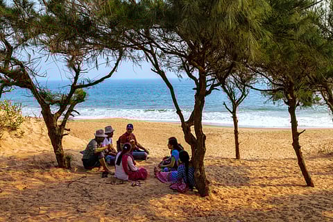 A family enjoying a leisurely day at the beach at Puri