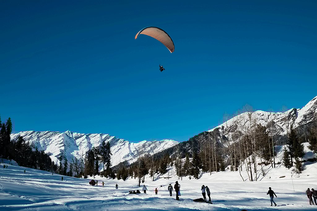 Enjoy paragliding over snowcapped valleys