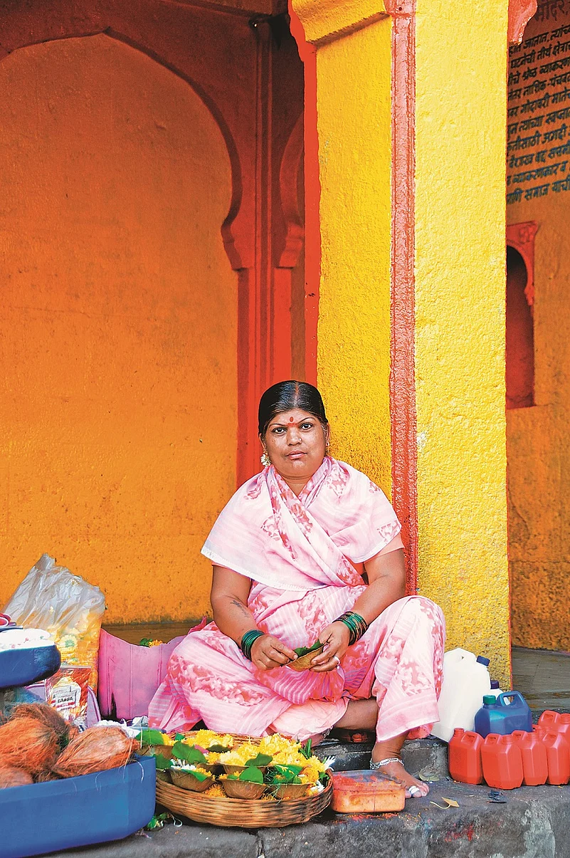 A woman sells offerings near a temple