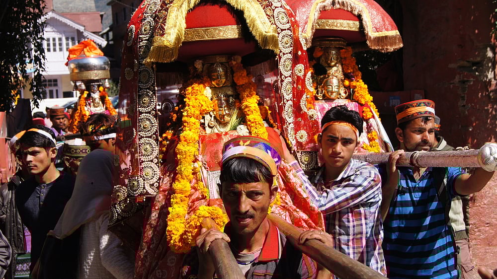 People carry the local deities on their shoulders on their way to Kullu
