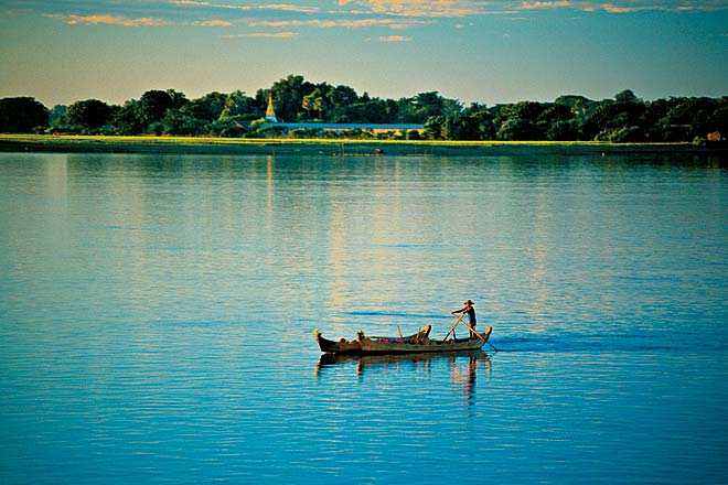 A fisherman rows on the Irawaddy