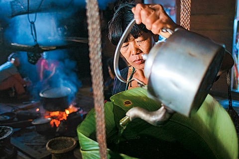 An Adi woman prepares apong, the ubiquitous Arunachali grain wine, from fermented rice, in Karko village in Upper Siang