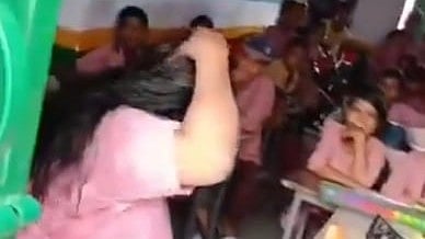 মাথায় তেল মালিশ করছেন শিক্ষিকা