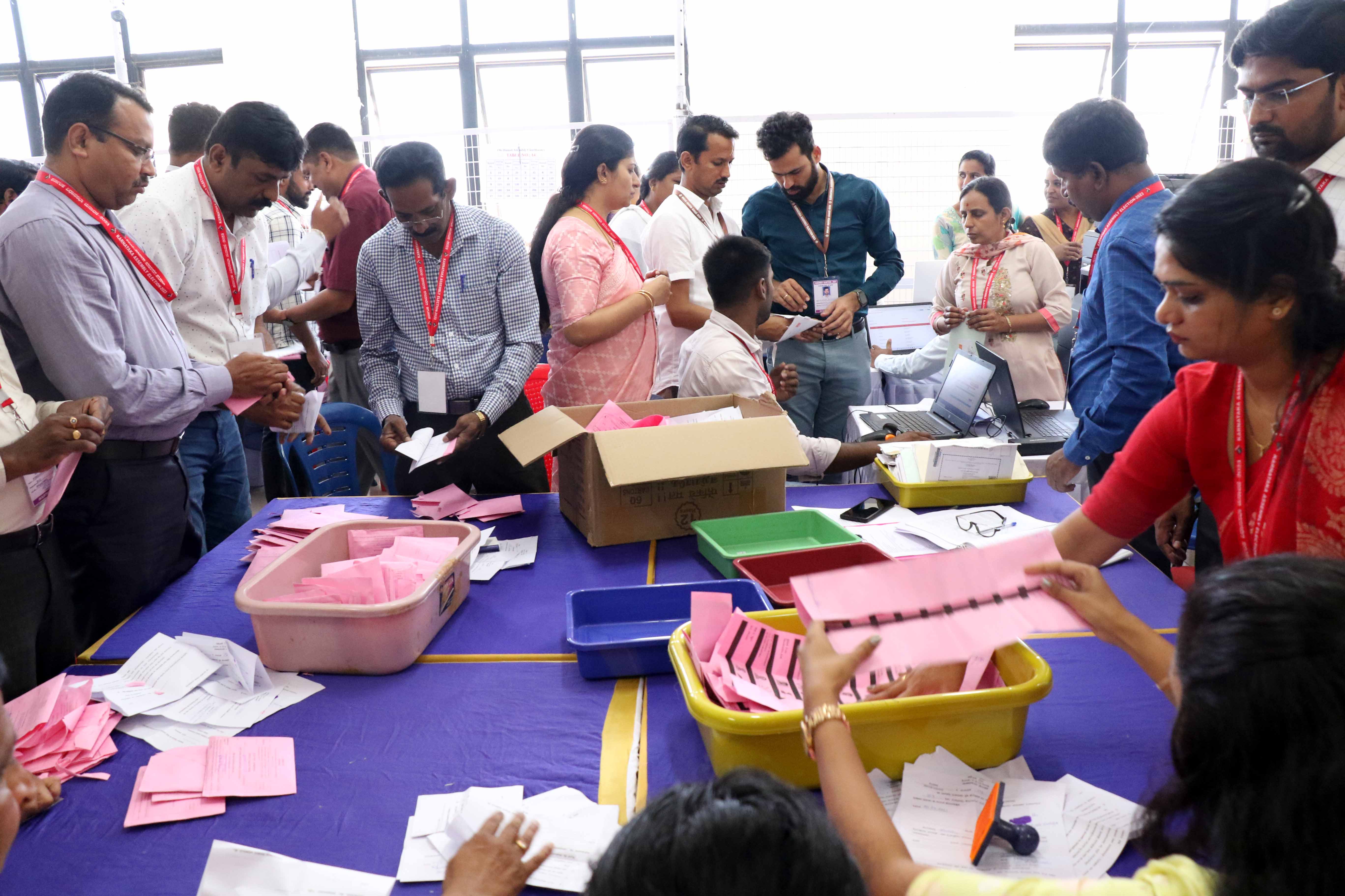 ಸೇವಾ ಮತಪತ್ರಗಳ ಎಣಿಕೆಯಲ್ಲಿ ನಿರತರಾಗಿರುವ ಸಿಬ್ಬಂದಿ