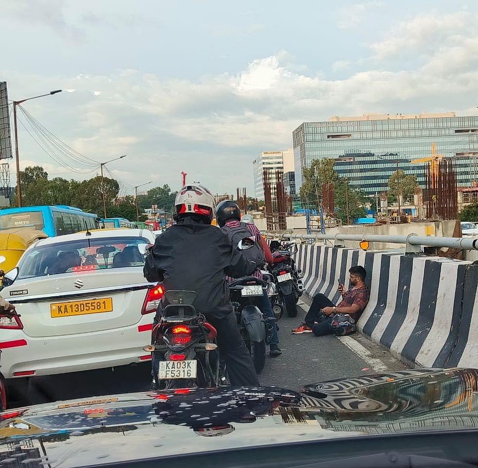 ಬೆಂಗಳೂರು | ವಿಪರೀತ ದಟ್ಟಣೆ: ಮೇಲ್ಸೇತುವೆಯಲ್ಲಿ ಕುಳಿತ ಟೆಕಿ