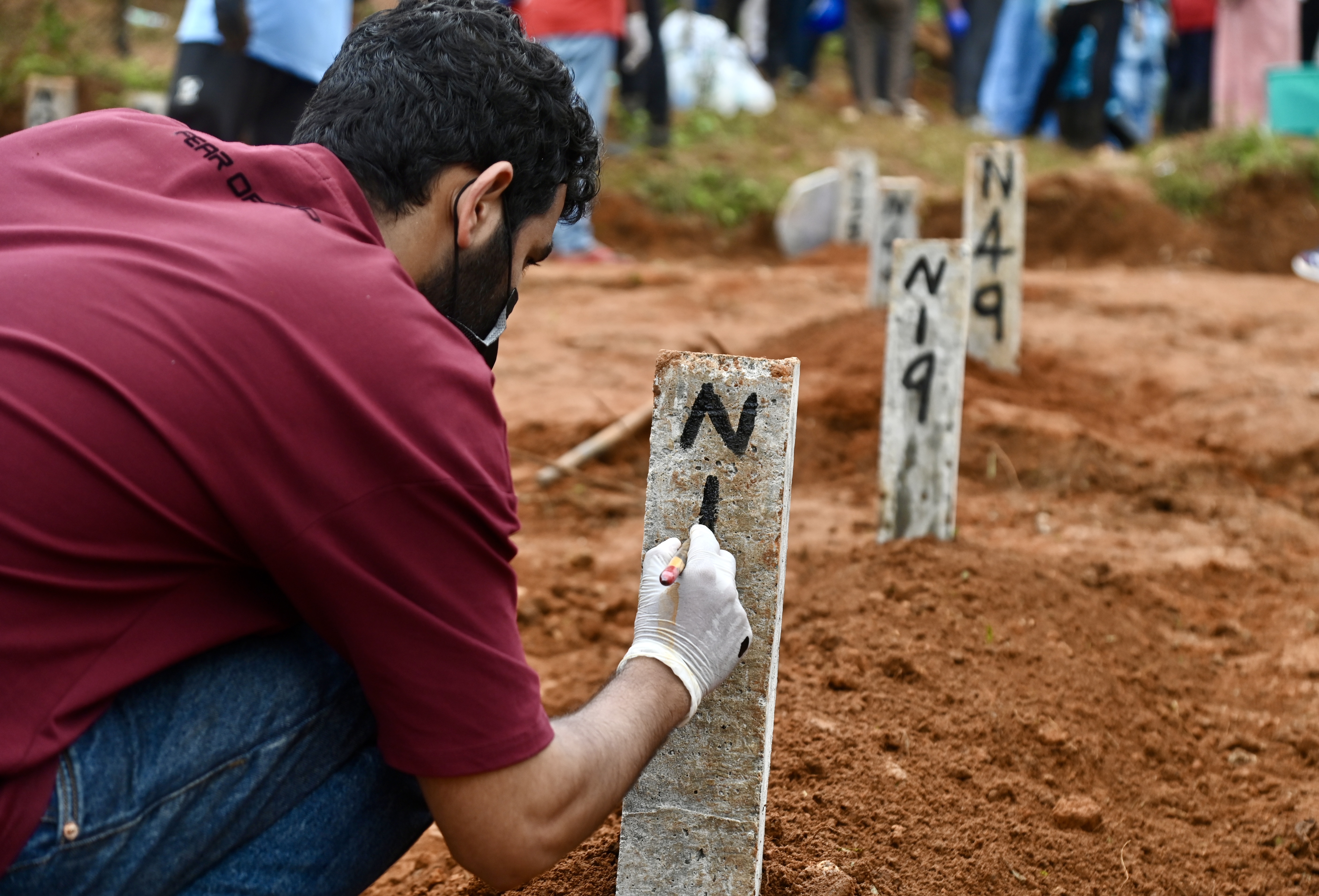 ಭೂಕುಸಿತದಿಂದ ಸಾವಿಗೀಡಾದವರ ಪೈಕಿ ಗುರುತು ಪತ್ತೆಯಾಗದ ಮೃತದೇಹದ ಅಂತ್ಯಸಂಸ್ಕಾರ ಮಾಡಿದ ಜಾಗದಲ್ಲಿ ಡಿಎನ್‌ಎ ಮಾದರಿಯ ಸಂಖ್ಯೆ ನಮೂದಿಸುತ್ತಿರುವ ಸಿಬ್ಬಂದಿ –ಪ್ರಜಾವಾಣಿ ಚಿತ್ರ–ಫಕ್ರುದ್ದೀನ್‌ ಎಚ್‌.