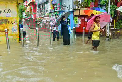 ಮಳೆಯ ನಡುವೆ ಜನರು ಪ್ರಯಾಣಿಸುತ್ತಿರುವುದು