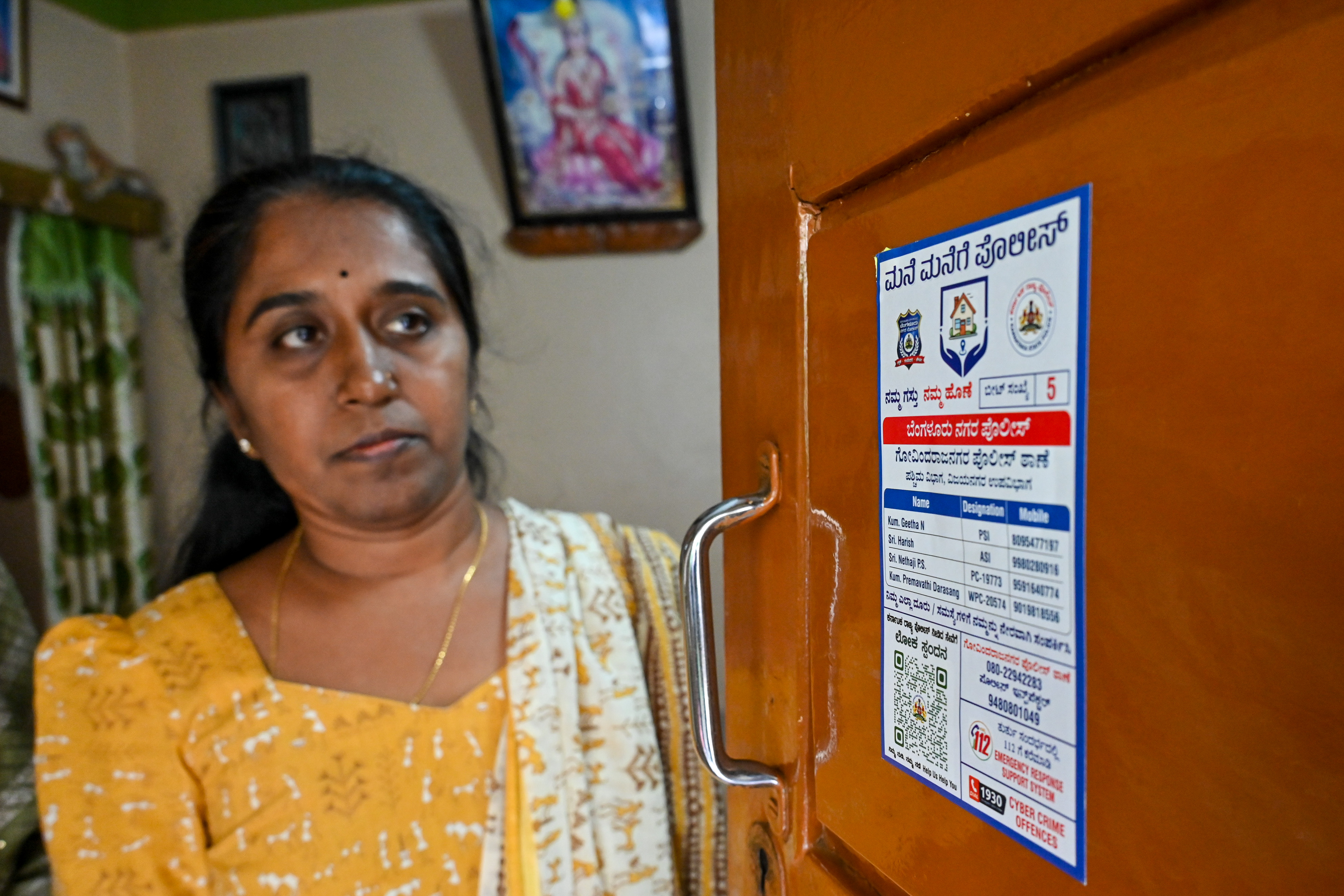 ‘ಮನೆ ಮನೆಗೆ ಪೊಲೀಸ್’ ಕಾರ್ಯಕ್ರಮದ ಸ್ಟಿಕರ್‌ ಅನ್ನು ಮಹಿಳೆಯೊಬ್ಬರು ಪರಿಶೀಲಿಸಿದರು 