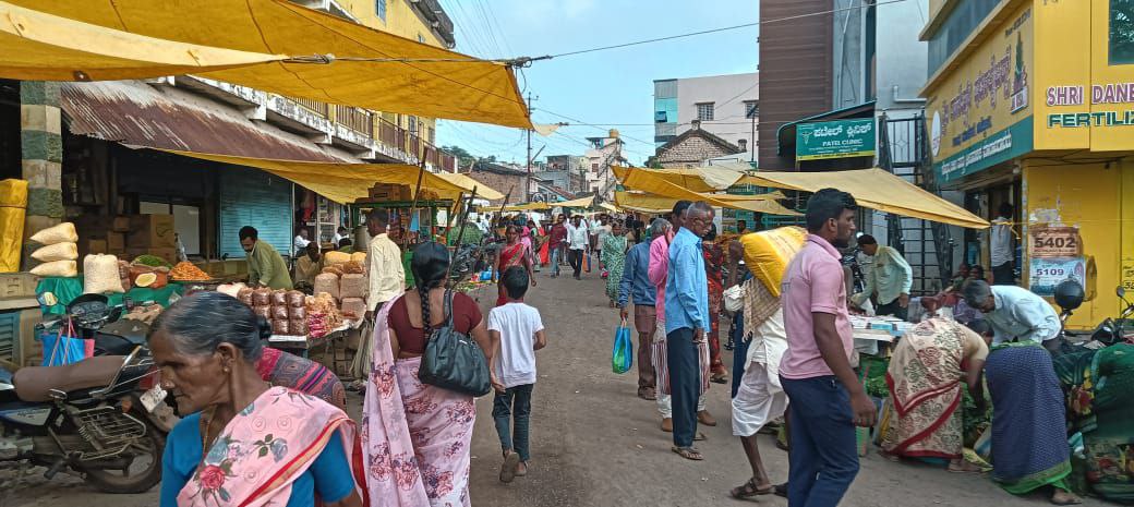 ನೆರಳಿನ ವ್ಯವಸ್ಥೆ ಇಲ್ಲದ್ದರಿಂದ ಚಿಕ್ಕೋಡಿಯ ಗಾಂಧಿ ಮಾರುಕಟ್ಟೆಯಲ್ಲಿ ವ್ಯಾಪಾರಿಗಳು ಪ್ಲಾಸ್ಟಿಕ್ ಹಾಳೆ ಕಟ್ಟಿಕೊಂಡು ವ್ಯಾಪಾರದಲ್ಲಿ ತೊಡಗಿರುವುದು