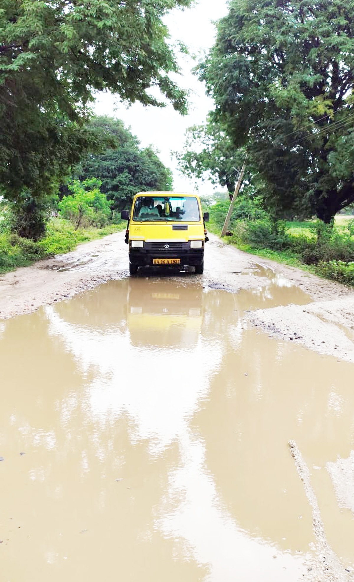 ಕೆಸರು ಗದ್ದೆಯಂತಾಗಿರುವ ನರೇಗಲ್-ತೊಂಡಿಹಾಳ ಮಾರ್ಗದ ರಸ್ತೆಯಲ್ಲಿ ಬರುತ್ತಿರುವ ಶಾಲಾ ವಾಹನ