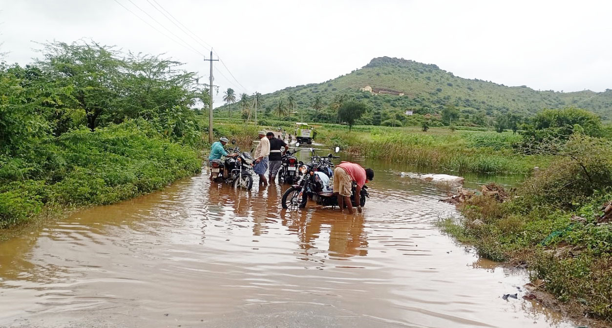 ಹರಪನಹಳ್ಳಿ ತಾಲ್ಲೂಕು ಹಲುವಾಗಲು-ಗರ್ಭಗುಡಿ ಗ್ರಾಮಕ್ಕೆ ಸಂಪರ್ಕ ಕಲ್ಪಿಸುವ ರಸ್ತೆ ಜಲಾವೃತಗೊಂಡಿದ್ದು ಬೈಕ್ ಗಳನ್ನು ತೊಳೆಯುತ್ತಿರುವ ಗ್ರಾಮಸ್ಥರು.