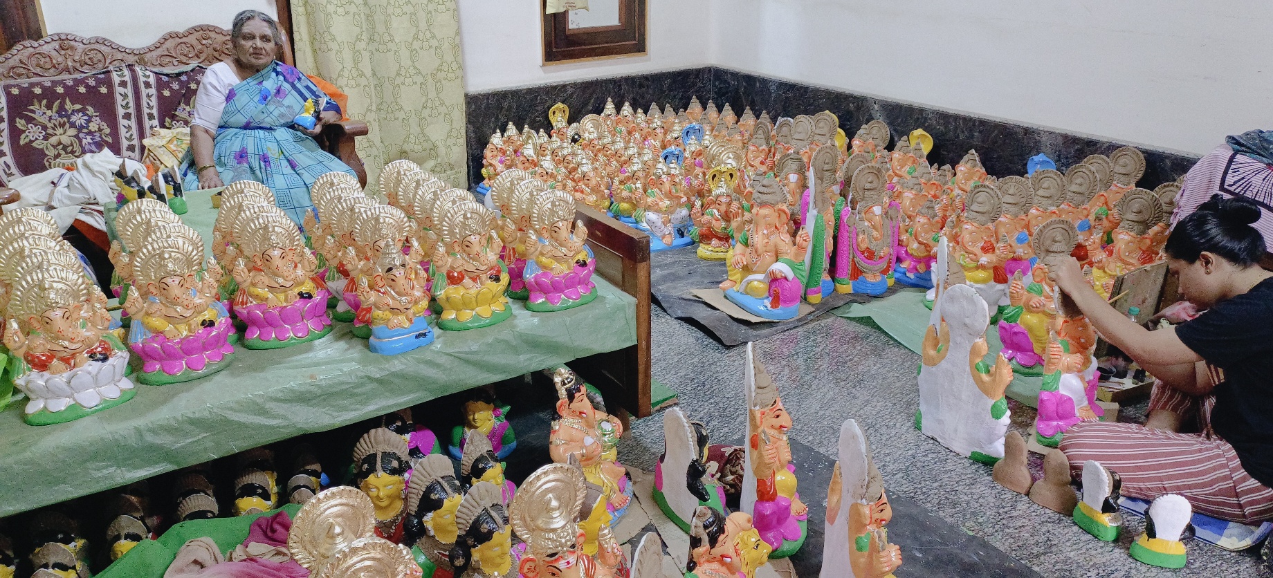 ಚಿಕ್ಕ ಗಣಪತಿ ಮೂರ್ತಿಗೆ ಅಂತಿಮ ಸ್ಪರ್ಶ ನೀಡುತ್ತಿರುವ ಕಲಾವಿದೆ