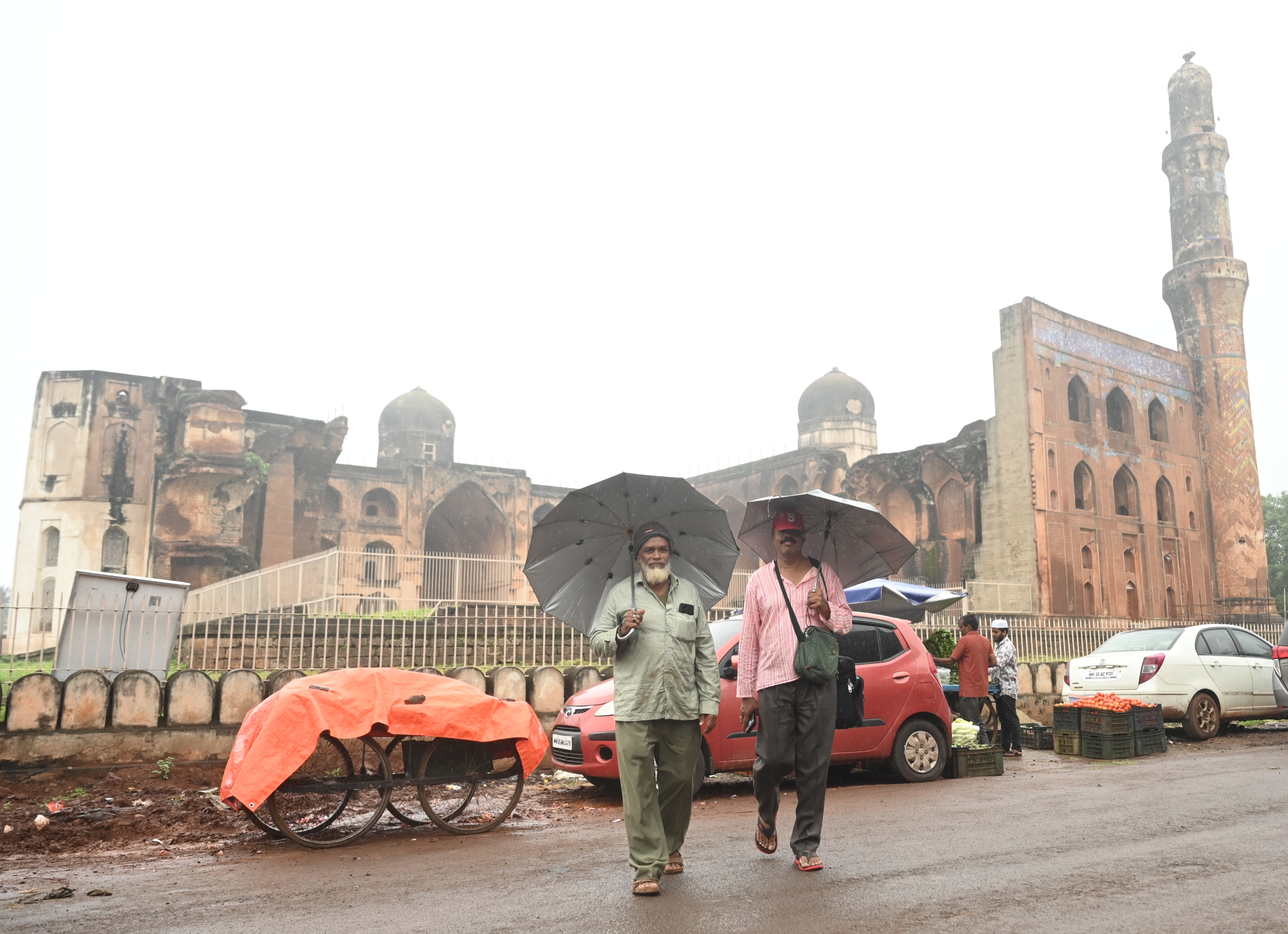 ಬೀದರ್‌ನ ಮಹಮೂದ್‌ ಗಾವಾನ್‌ ಸ್ಮಾರಕ ಎದುರಿನ ರಸ್ತೆಯಲ್ಲಿ ಮಳೆಯಲ್ಲಿ ಕೊಡೆ ಹಿಡಿದುಕೊಂಡು ಹೆಜ್ಜೆ ಹಾಕಿದ ಜನ 