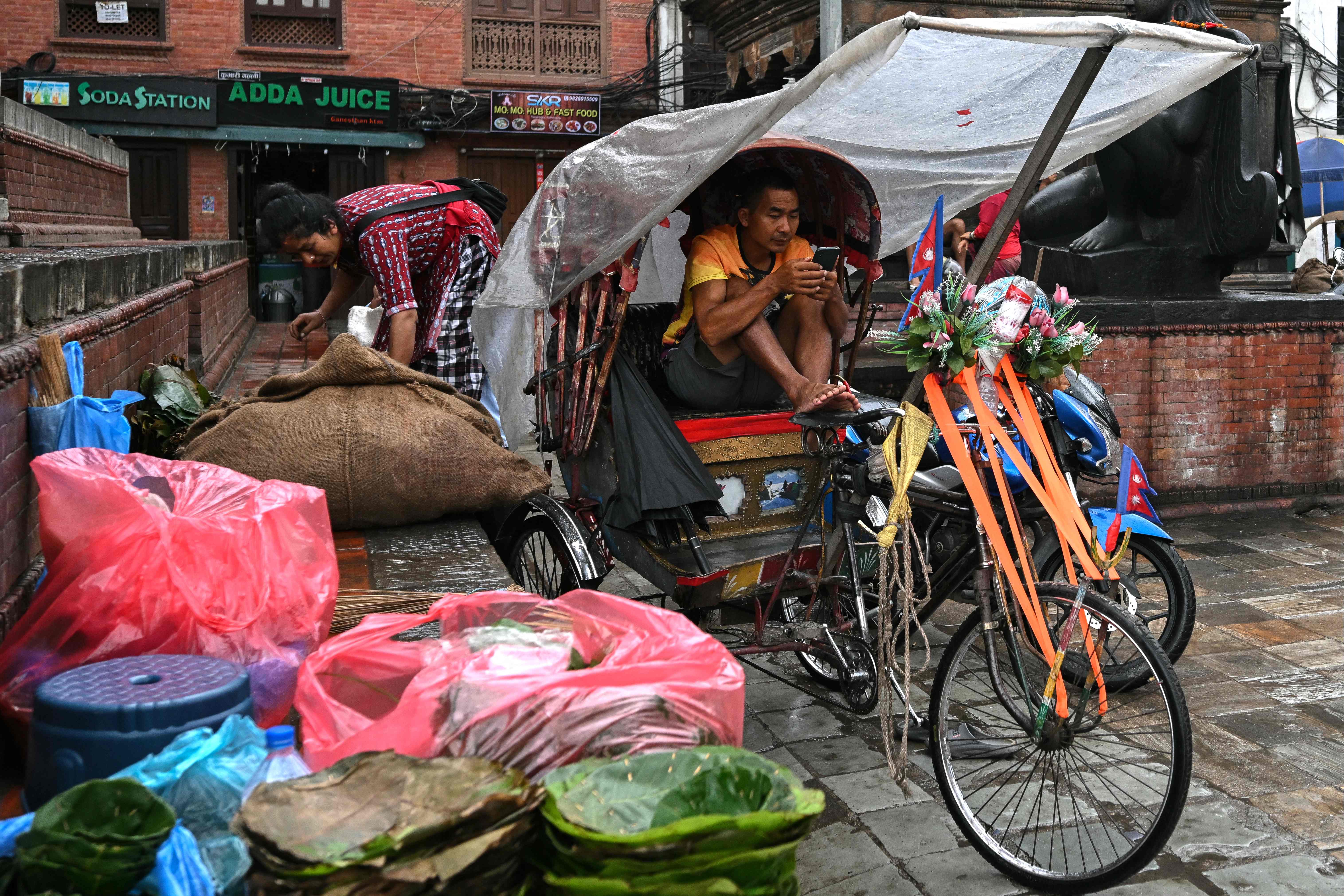 ಕಠ್ಮಂಡುವಿನ ಡಾಬರ್ ಸ್ಕ್ವೇರ್‌ನಲ್ಲಿ  ಆಟೊರಿಕ್ಷಾ ಚಾಲಕರೊಬ್ಬರು ಶನಿವಾರ ಮೊಬೈಲ್‌ನಲ್ಲಿ ತಲ್ಲೀನನಾಗಿದ್ದರು  