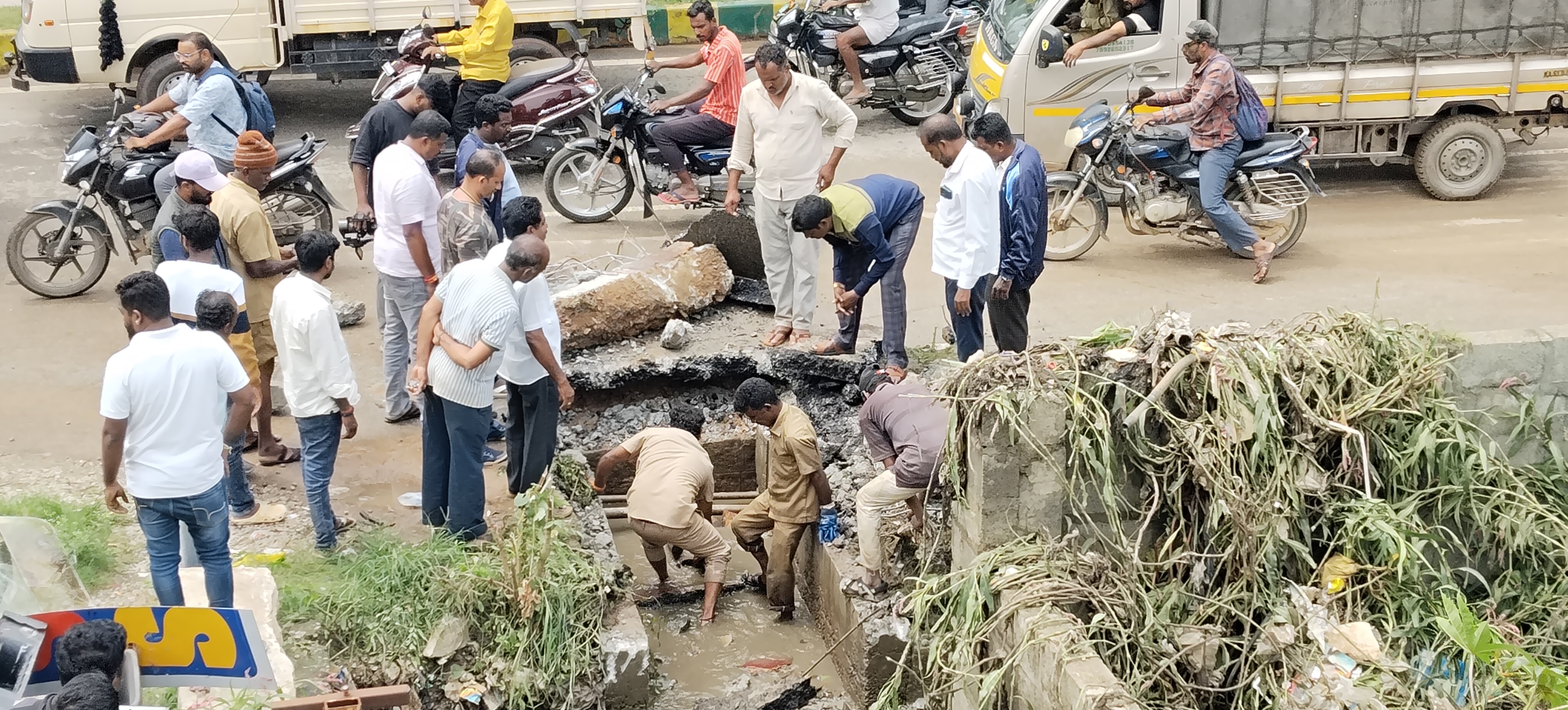 ನಗರಸಭೆ ಸಿಬ್ಬಂದಿ  ಮಳೆ ನೀರು ಹರಿಯುವಂತೆ ಮಾಡುತ್ತಿರುವುದು