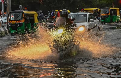 ಬೆಂಗಳೂರು ನಗರದ ಎಂ.ಜಿ ರಸ್ತೆಯ ಗಾಂಧಿ ಪ್ರತಿಮೆ ಬಳಿ ಜನರು  ಮಳೆಯಲ್ಲಿ ಸಾಗಿದರು 