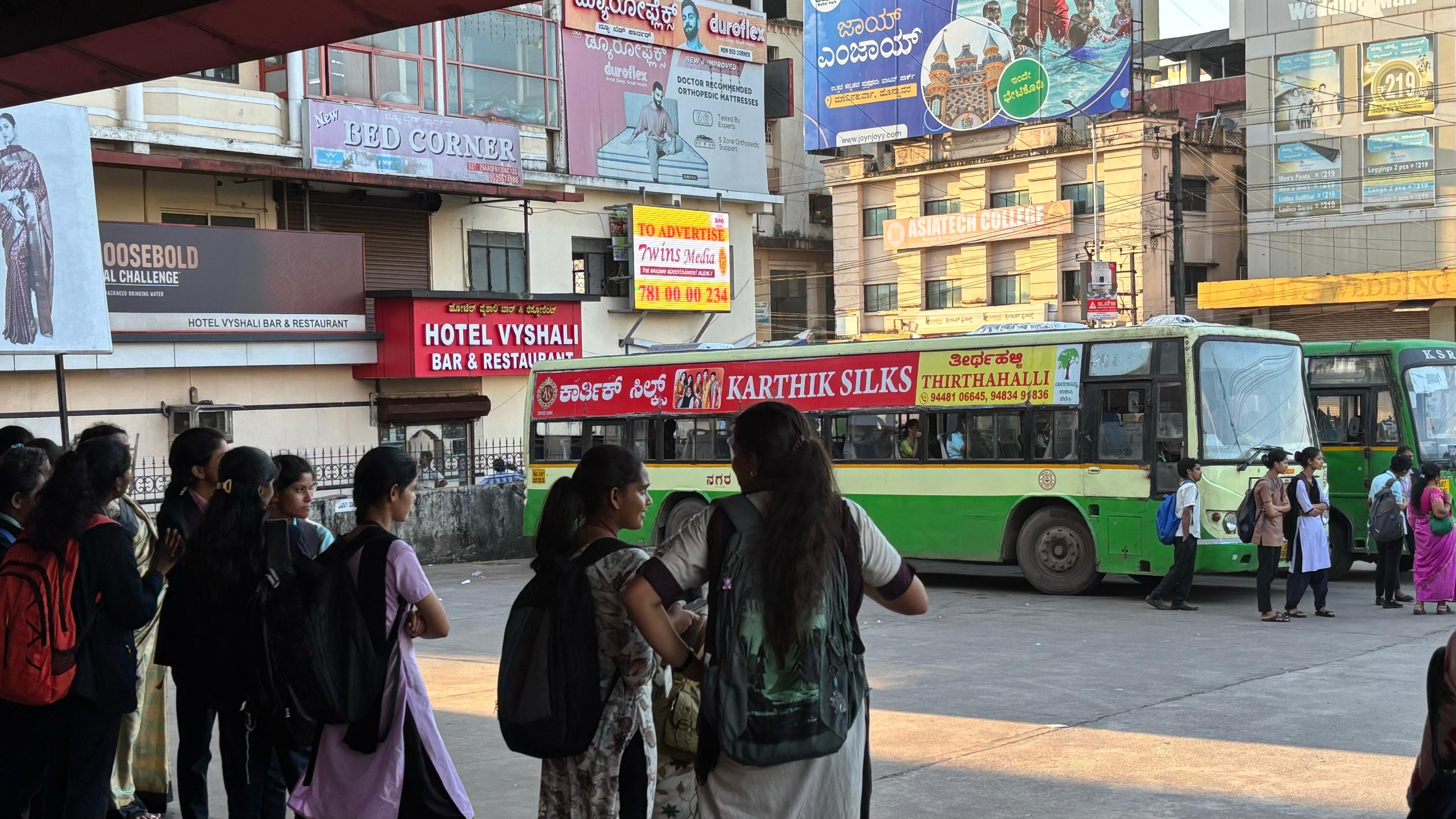 ಸರ್ಕಾರಿ ಬಸ್‌ಗಾಗಿ ಕಾಯುತ್ತಿರುವ ವಿದ್ಯಾರ್ಥಿನಿಯರು