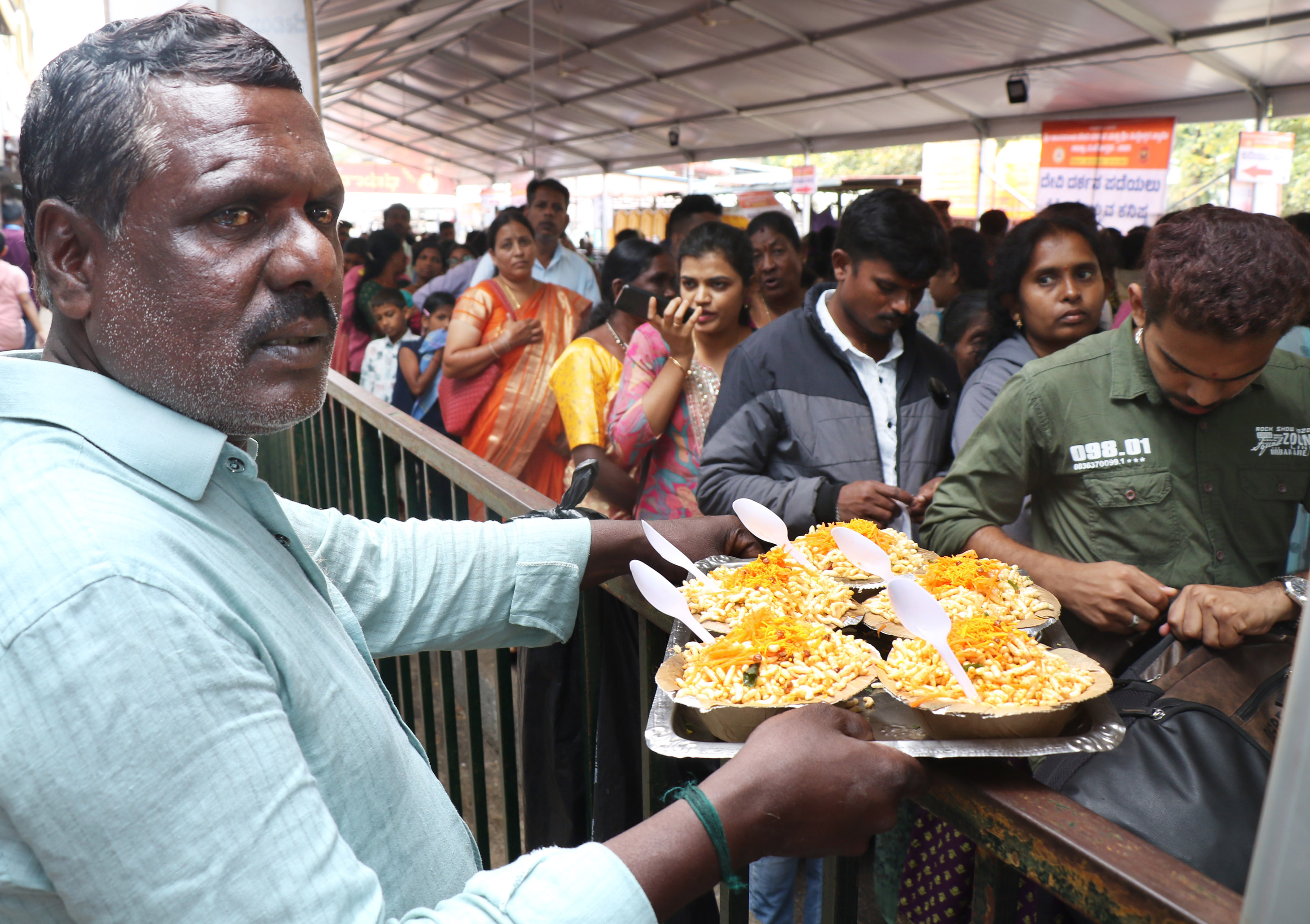 ಸರದಿಯಲ್ಲಿ ನಿಂತವರಿಗೆ ಚುರುಮರಿ ಮಾರಾಟ ಮಾಡುತ್ತಿದ್ದ ವ್ಯಾಪಾರಿ.