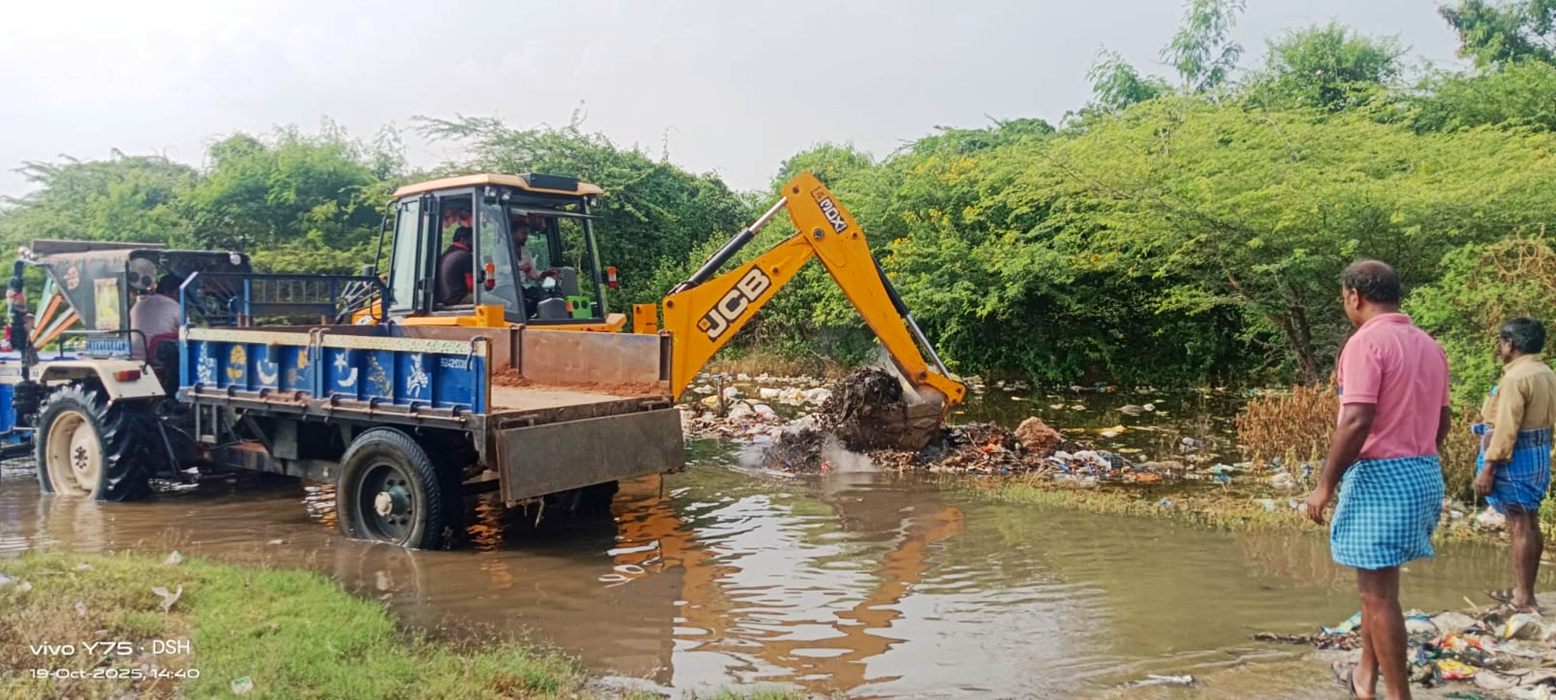 ಕೊಳದಲ್ಲಿನ ಕೊಳಚೆ ಮುಳ್ಳು ಕಂಟಿ ತೆರವುಗೊಳಿಸುತ್ತಿರುವ ಜೆಸಿಬಿ ಯಂತ್ರ