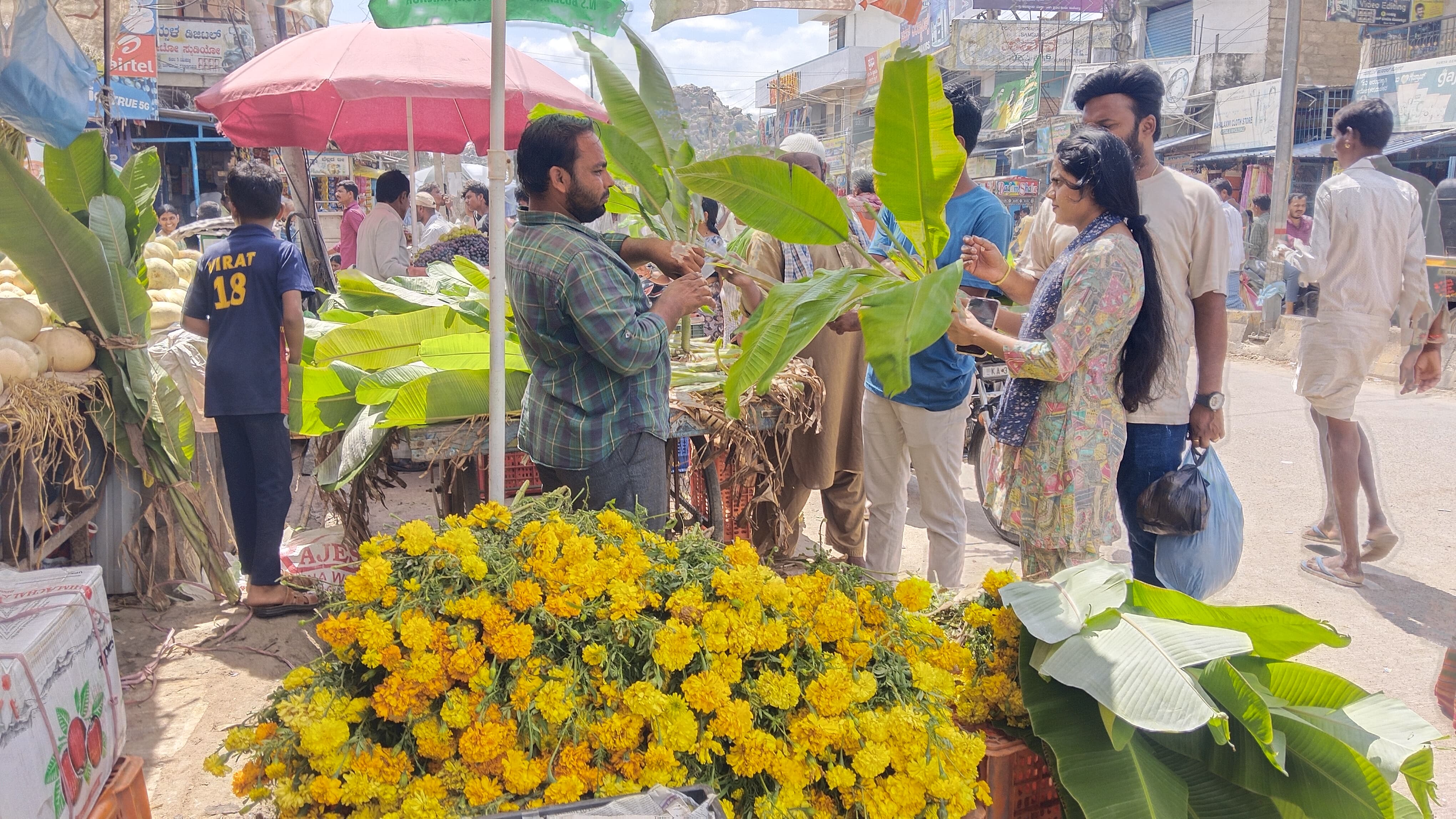 ಮಾನ್ವಿ ಪಟ್ಟಣದಲ್ಲಿ ಹೂವು ಬಾಳೆ ಎಲೆ ಖರೀದಿಸುತ್ತಿರುವ ಜನರು