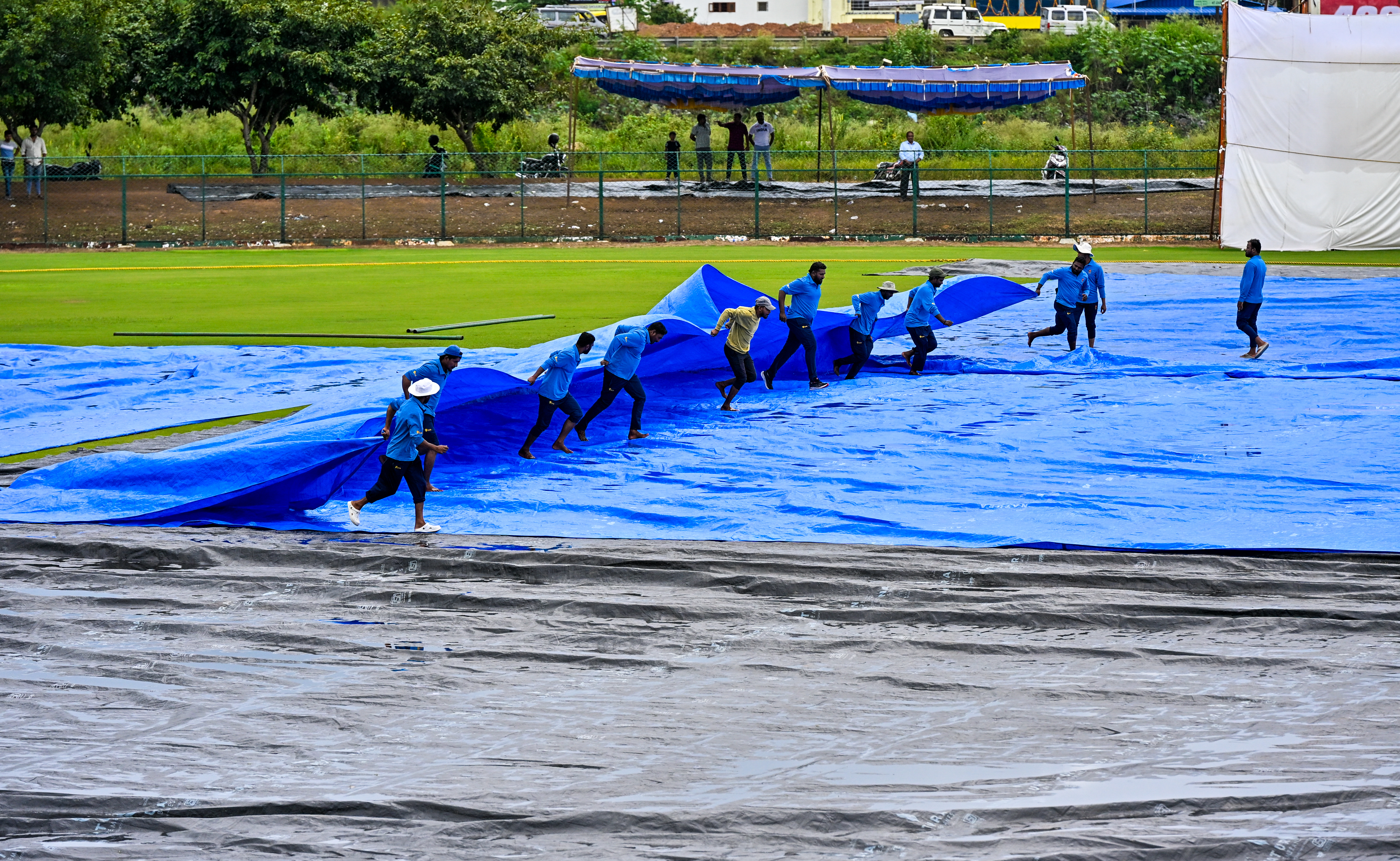 ಭಾನುವಾರ ಮಳೆ ನಿಂತ ನಂತರ ಪಿಚ್‌ ಮೇಲೆ ಹಾಕಿದ್ದ ಟಾರ್ಪಾಲ್‌ಗಳನ್ನು ತೆರವುಗೊಳಿಸುವಲ್ಲಿ ನಿರತರಾಗಿದ್ದ ಮೈದಾನದ ಸಿಬ್ಬಂದಿ ‌ಪ್ರಜಾವಾಣಿ ಚಿತ್ರ/ ಕೃಷ್ಣ ಕುಮಾರ್ ಪಿ.ಎಸ್.  