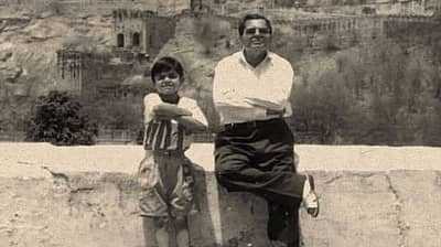 ಶಾಲೆಯ ರಜೆಯಲ್ಲಿರುವಾಗ ತಂದೆಯ ಜೊತೆಗೆ ನಿಂತು ಬಾಲಕ ವಿರಾಟ್ ಕೊಹ್ಲಿ ನಗುತ್ತಿರುವುದು. 