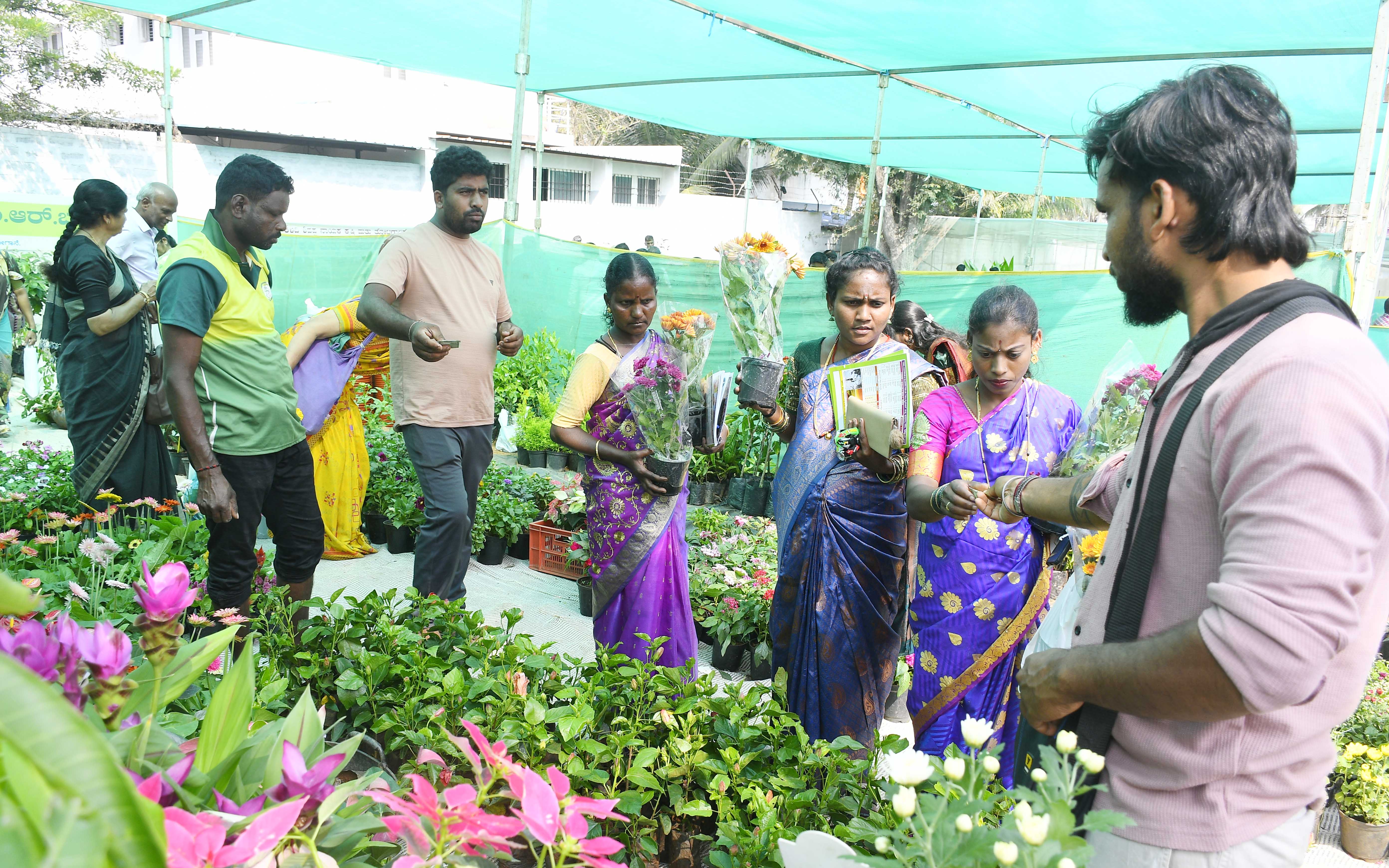 ಮೇಳದ ನರ್ಸರಿಯಲ್ಲಿ ಹೂವಿನ ಗಿಡಗಳ ಖರೀದಿಯಲ್ಲಿ ನಿರತ ಮಹಿಳೆಯರು