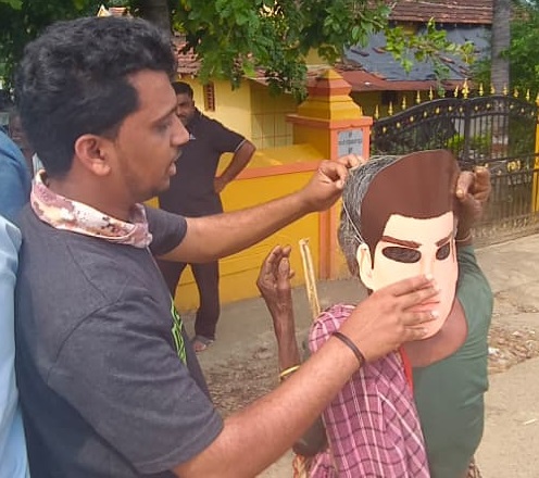 ವೃದ್ಧೆಯೊಬ್ಬರಿಗೆ ಮುಖವಾಡ ಹಾಕುತ್ತಿರುವ ಅರಣ್ಯ ಇಲಾಖೆ ಸಿಬ್ಬಂದಿ 