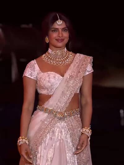 ಬಿಳಿ ಲೆಹೆಂಗಾ ಸೀರೆಗೆ ಒಪ್ಪುವಂತೆ ಭಾರವಾದ ಹಾರ, ಅದಕ್ಕೆ ಹೊಂದಿಕೆಯಾಗುವ ಮಾಂಗ್ ಟಿಕ್ಕಾ, ಬಳೆಗಳು ಮತ್ತು ಸುಂದರವಾದ ಸೊಂಟಪಟ್ಟಿಯನ್ನು ಧರಿಸಿದ್ದ ಪ್ರಿಯಾಂಕಾ  ರಾಜಕುಮಾರಿಯಂತೆ ಕಂಗೊಳಿಸಿದ್ದಾರೆ. 