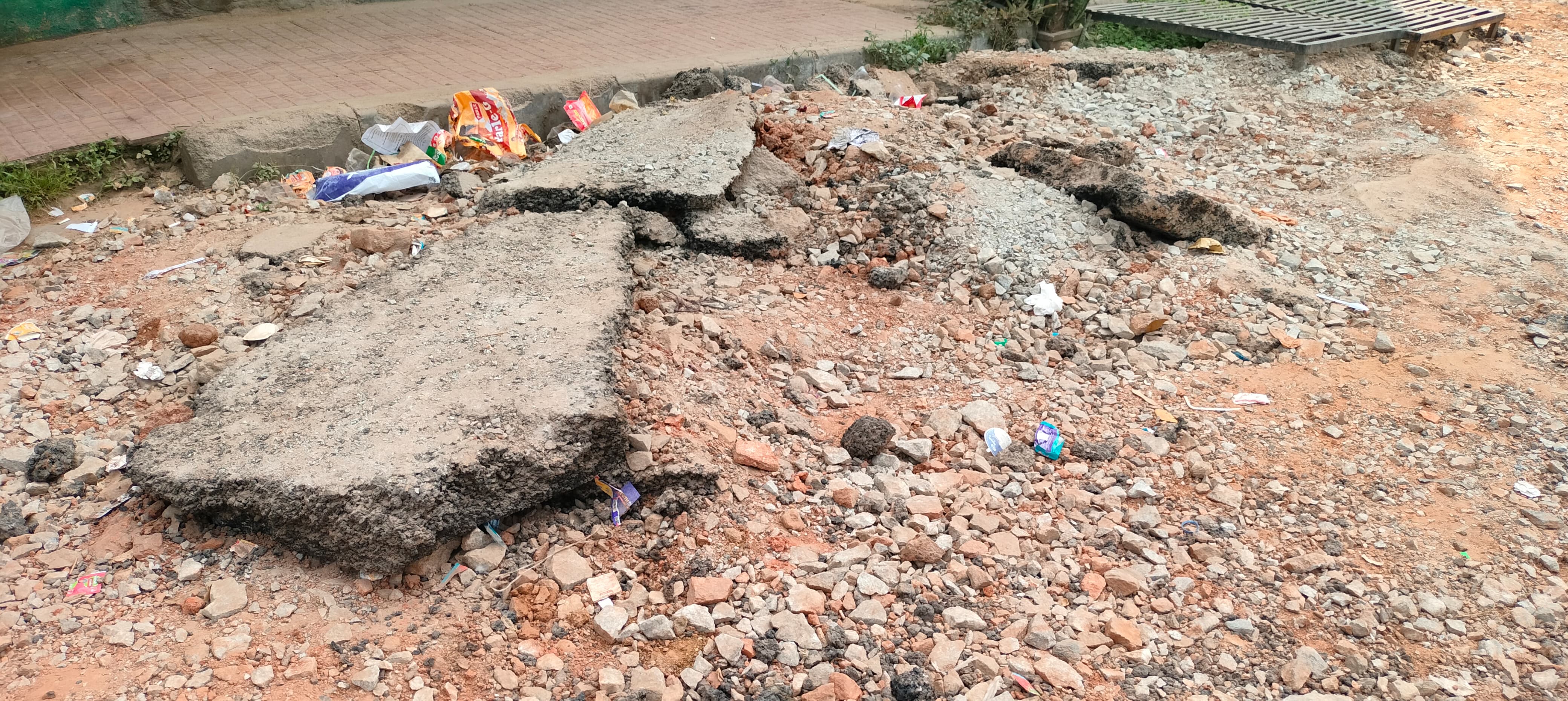 ಅಂಗಡಿಗಳ ಮುಂಭಾಗದಲ್ಲಿ ಡಾಂಬರ ರಸ್ತೆ ಅಗೆದು ಹಾಗೆ ಬಿಟ್ಟಿರುವುದು