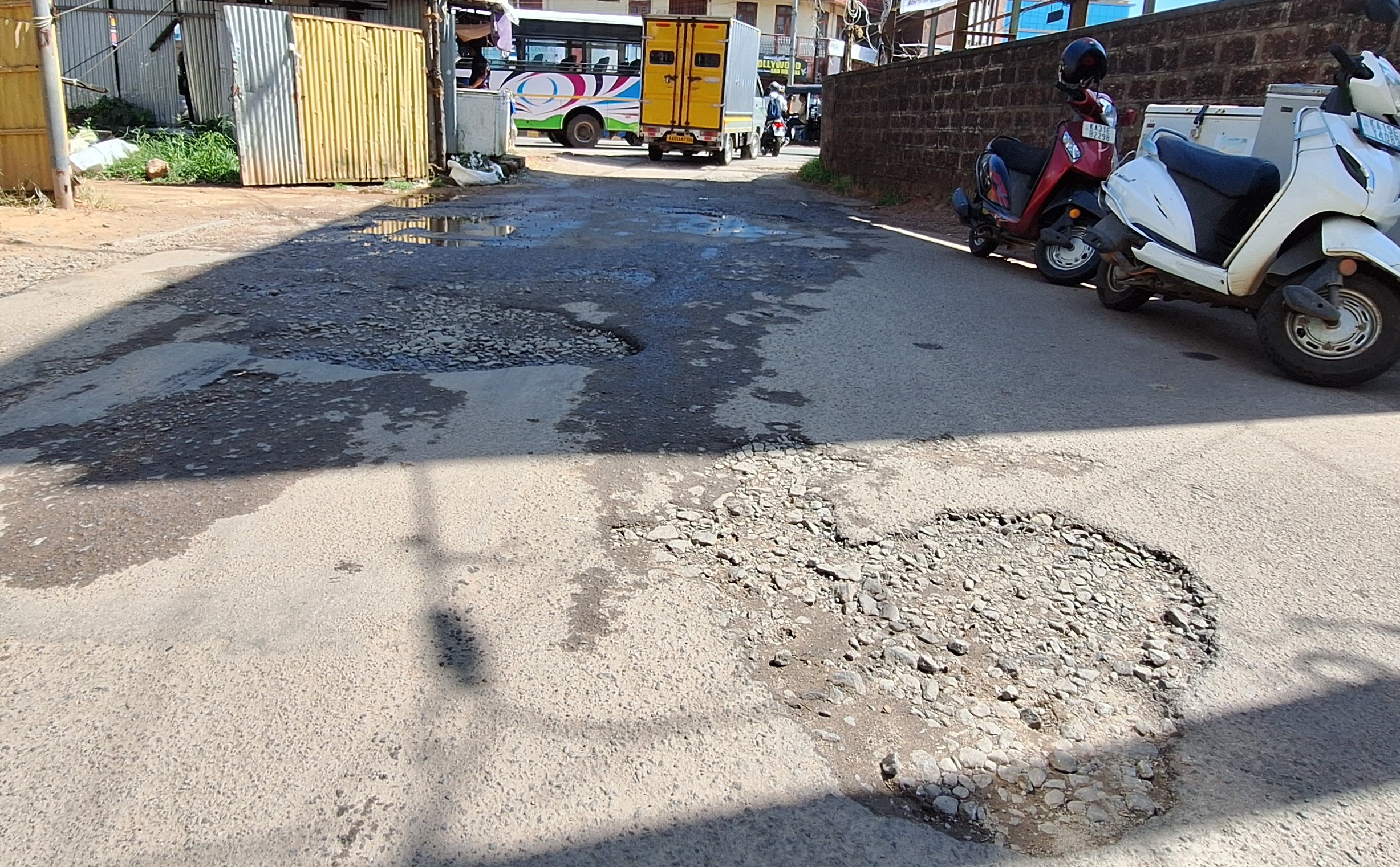 ಡಾಂಬರ್ ಕಿತ್ತು ಹೋಗಿರುವ ಮಾರ್ಕೆಟ್ ಪಕ್ಕದ ರಸ್ತೆ