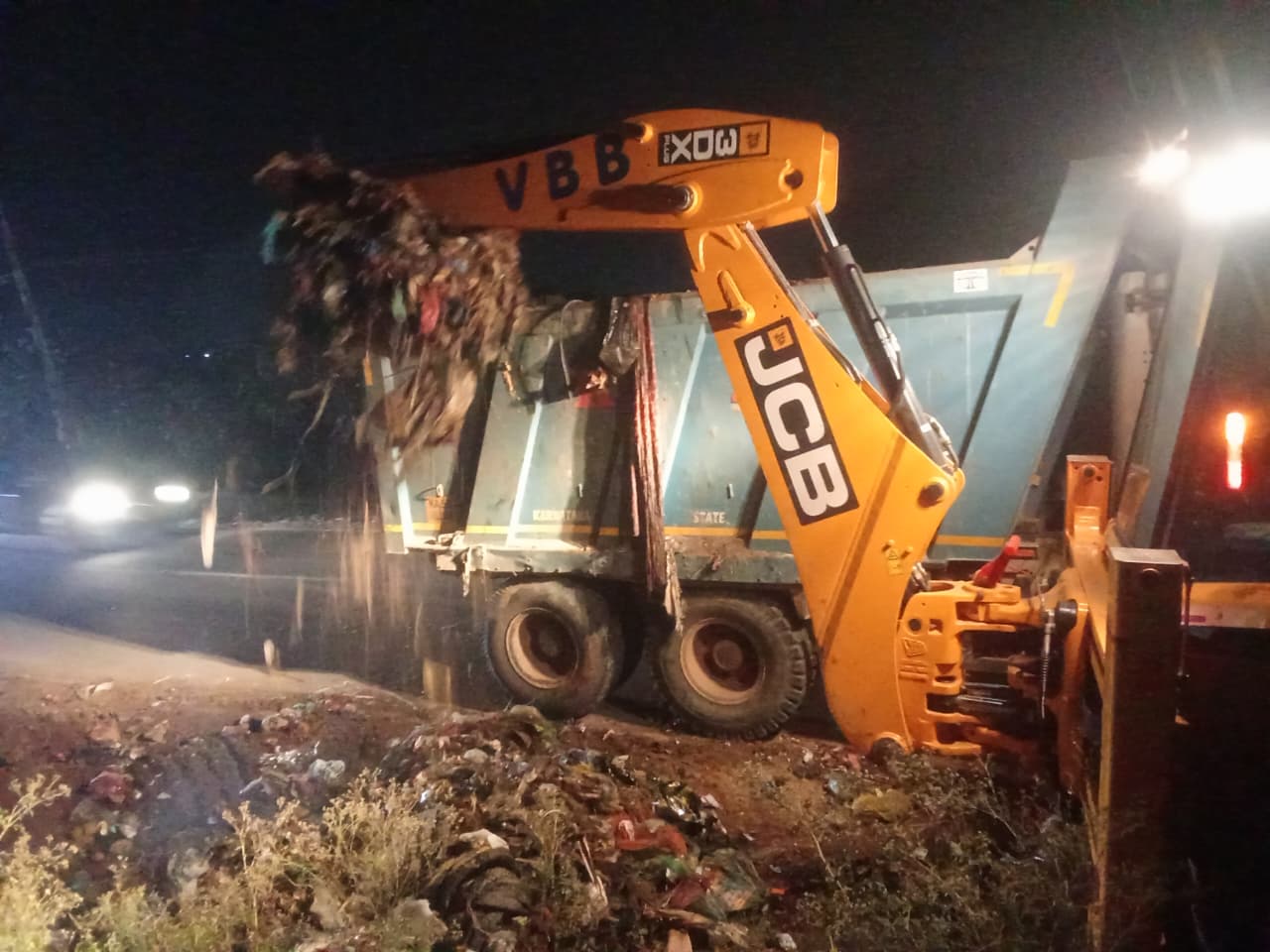 ಸಮೇತನಹಳ್ಳಿ ಗ್ರಾಮದಲ್ಲಿ ರಸ್ತೆಬದಿ ಕೆರೆಕಟ್ಟೆ ಕೆರೆ ಅಂಗಳ ವಸತಿ ಸಮುಚ್ಛಯಗಳ ಬಳಿ ಅನುಪಯುಕ್ತ ತ್ಯಾಜ್ಯ ಪ್ಲಾಸ್ಟಿಕ್ ಹಾಗೂ ಕಸದ ರಾಶಿಯನ್ನು ಜೆಸಿಬಿ ಮತ್ತು ಟಿಪ್ಪರ್ ಮೂಲಕ ವಿಲೇವಾರಿ ಮಾಡುತ್ತಿರುವುದು