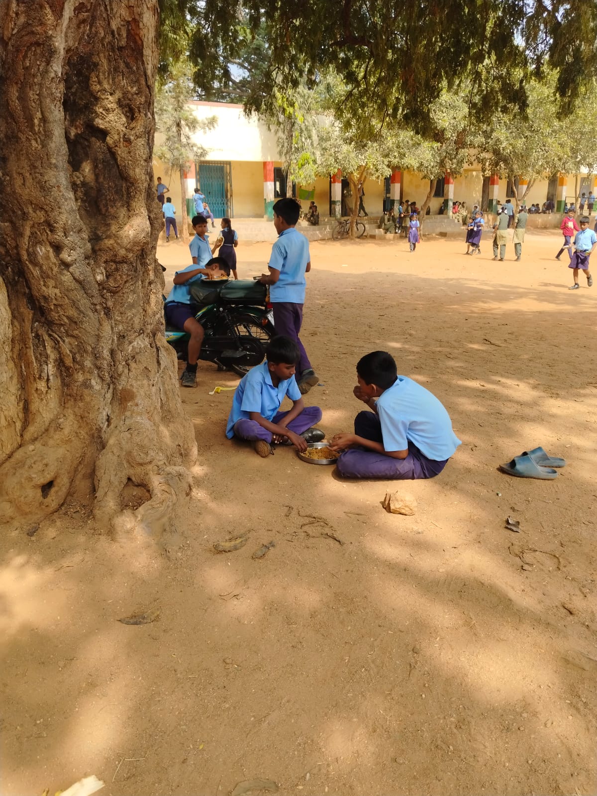 ಮೈದಾನದಲ್ಲೇ ಊಟ ಮಾಡುತ್ತಿರುವ ಮಕ್ಕಳು 