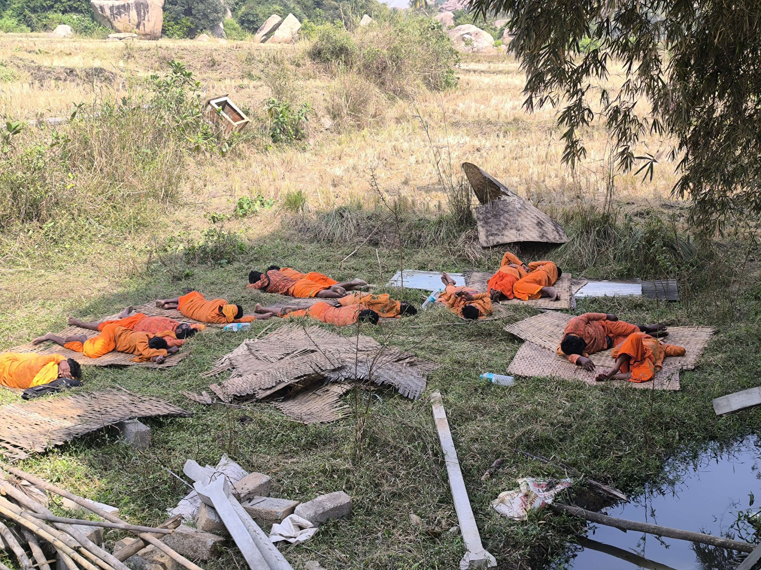 ಅಂಜನಾದ್ರಿ ಬೆಟ್ಟದ ಬಳಿನ ಜಮೀನಿನಲ್ಲಿ ಮಾಲಾಧಿಕಾರಿಗಳು ವಿಶ್ರಾಂತಿ ಮಾಡುತ್ತಿರುವುದು