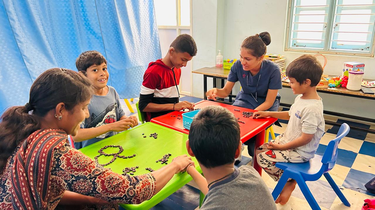 ವಿಶೇಷ ಶಿಕ್ಷಕಿಯೊಬ್ಬರು ಮಕ್ಕಳಿಗೆ ಗುಂಪು ಥೆರಪಿಯಲ್ಲಿ ಪಾಲ್ಗೊಂಡಿರುವುದು 