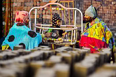 ಚಳಿ ಹೆಚ್ಚಾದ ಹಿನ್ನೆಲೆಯಲ್ಲಿ ಕಲಬುರಗಿಯ ಹೊರವಲಯ ಇಟ್ಟಂಗಿ ಬಟ್ಟಿಯ ಕಾರ್ಮಿಕ ದಂಪತಿ ಮಗುವಿಗೆ ತಂಪು ತಾಕದಂತೆ ಬೆಚ್ಚನೆ ಬಟ್ಟೆ ತೊಡಿಸಿರುವುದು.