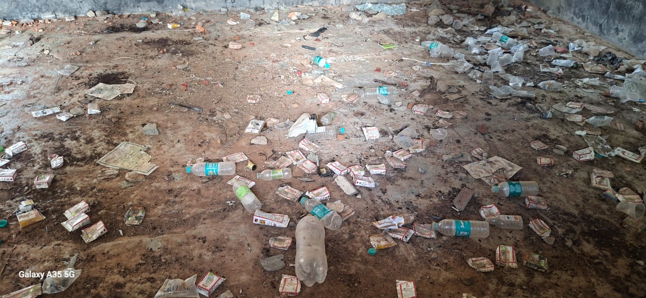 ಶಾಲೆ ಕೊಠಡಿಯಲ್ಲಿ ಬಿದ್ದಿರುವ ಮದ್ಯದ ಬಾಟಲಿ ಹಾಗೂ ಪ್ಲಾಸ್ಟಿಕ್ ವಸ್ತುಗಳು