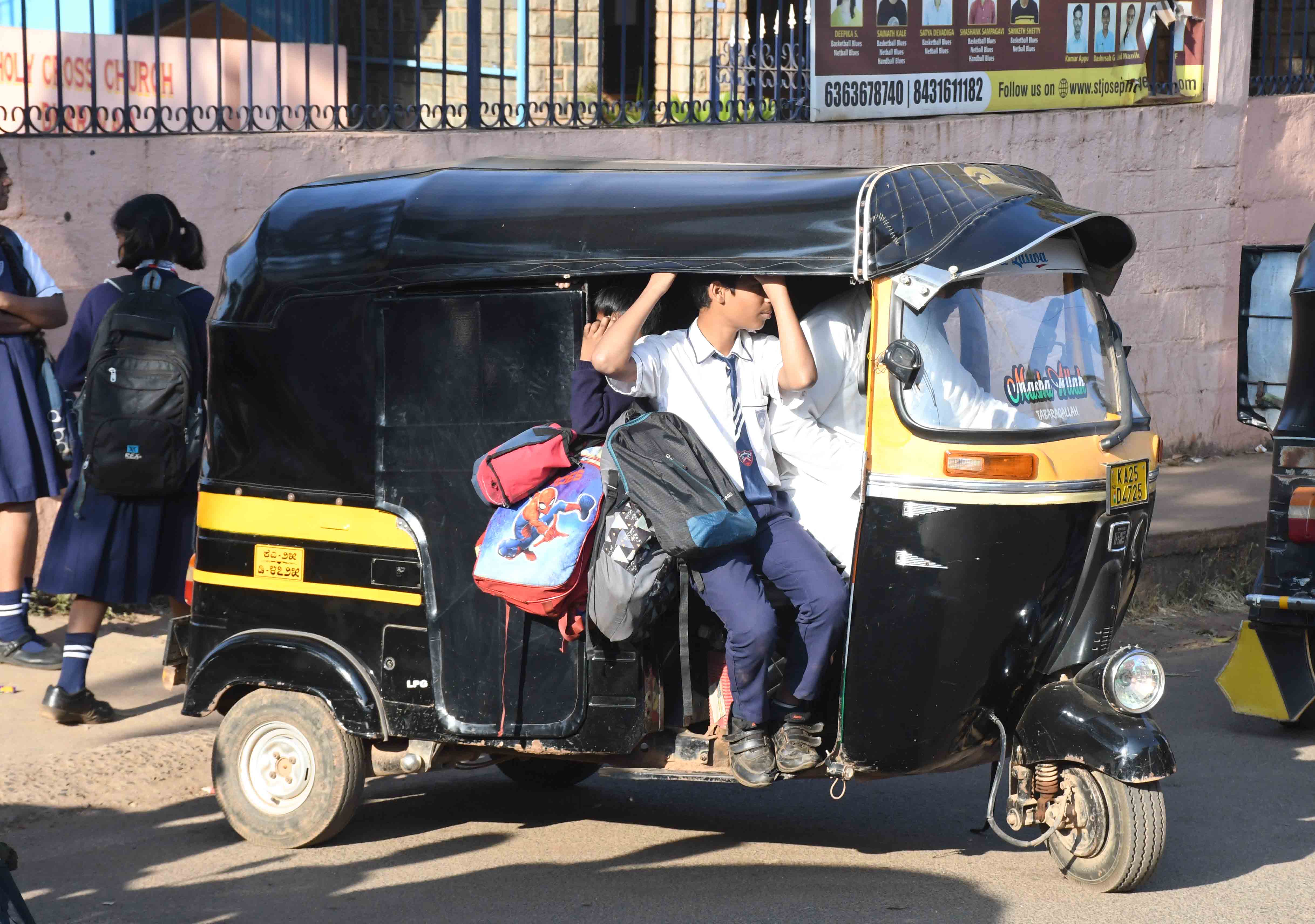 ಧಾರವಾಡದಲ್ಲಿ ಶಾಲಾ ಮಕ್ಕಳನ್ನು ಒಯ್ಯುವ ಆಟೊ ರಿಕ್ಷಾವೊಂದರ ಹೊರಭಾಗದಲ್ಲಿ ಬ್ಯಾಗುಗಳನ್ನು ನೇತು ಹಾಕಿರುವುದು ಚಾಲಕನ ಪಕ್ಕದ ಕಂಬಿ ಮೇಲೆ ವಿದ್ಯಾರ್ಥಿ ಕುಳಿತಿರುವುದುಪ್ರಜಾವಾಣಿ ಚಿತ್ರ:  ಬಿ.ಎಂ.ಕೇದಾರನಾಥ