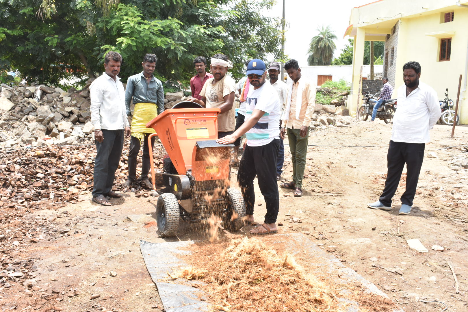 ಯಂತ್ರದ ಸಹಾಯದಿಂದ ತೆಂಗಿನ ಕಾಯಿಯ ಚಿಪ್ಪು ಮತ್ತು ಸಿಪ್ಪೆ ಪುಡಿ ಮಾಡುತ್ತಿರುವುದು