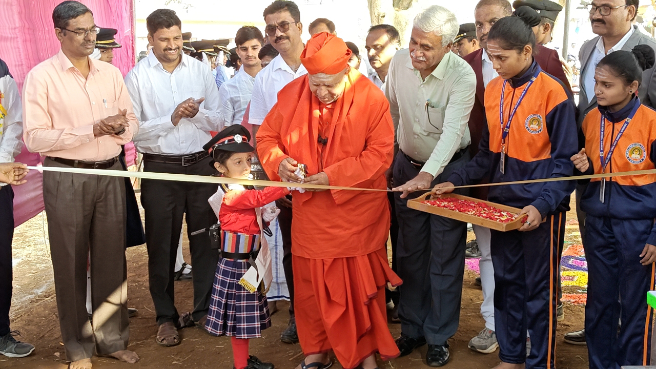 ತಾವು ಉದ್ಘಾಟಿಸಬೇಕಿದ್ದ ಕ್ರೀಡಾ ವಸ್ತುಪ್ರದರ್ಶನವನ್ನು ಶಾಲಾ ಪುಟಾಣಿಯೋರ್ವಳ ಕೈಹಿಡಿದು ಉದ್ಘಾಟಿಸಿದ ಶಿವಮೂರ್ತಿ ಶಿವಾಚಾರ್ಯ ಶ್ರೀಗಳು.