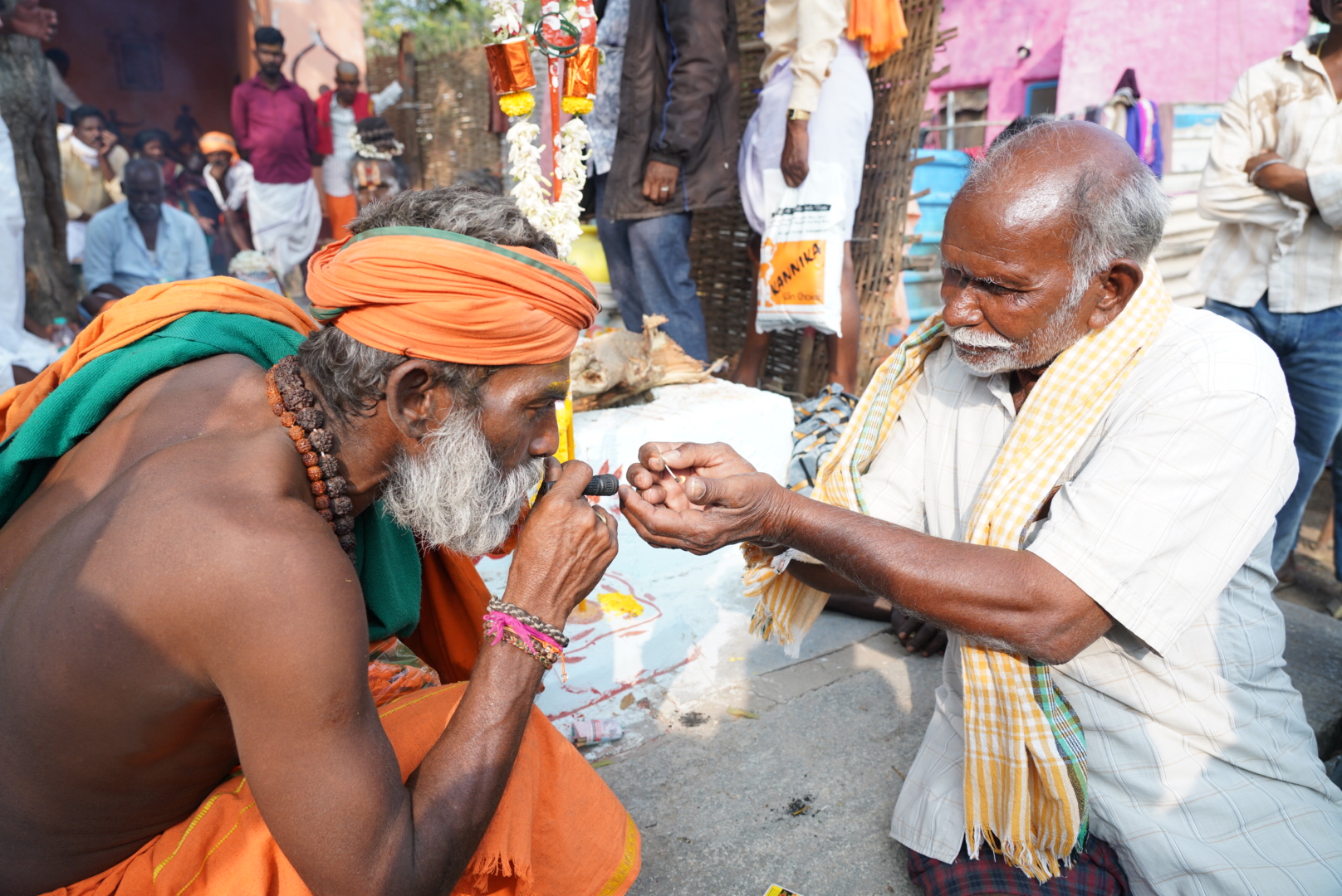 ಸಿಂಧನೂರು ತಾಲ್ಲೂಕಿನ ಅಂಬಾಮಠದ ಆವರಣದಲ್ಲಿ ಜಾತ್ರೆಯಲ್ಲಿ ಧೂಮಪಾನಕ್ಕೆ ಸಾಧುವೊಬ್ಬರ ಚಿಲುಮೆ ಹೊತ್ತಿಸಲು ಸಹಕರಿಸಿದ ಭಕ್ತ