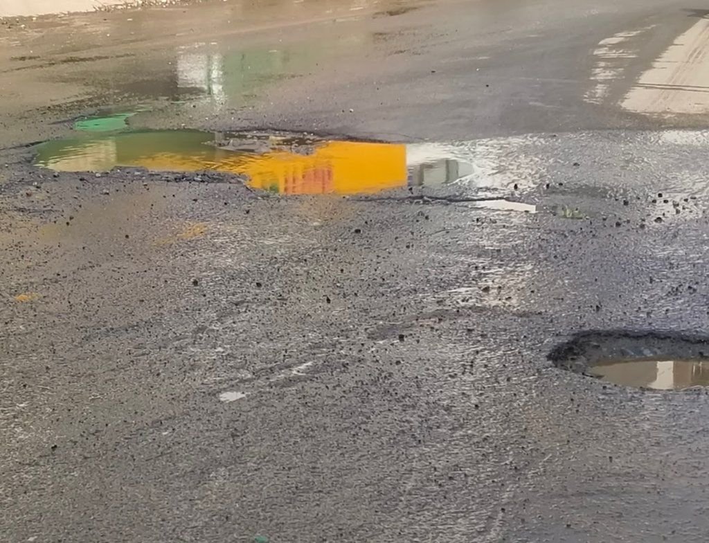 ಅಶೋಕನಗರಕ್ಕೆ ಸಂಪರ್ಕ ಕಲ್ಪಿಸುವ ರಸ್ತೆಯಲ್ಲಿ ಬಿದ್ದಿರುವ ಗುಂಡಿಗಳಲ್ಲಿ ತ್ಯಾಜ್ಯ ನೀರು ತುಂಬಿಕೊಂಡಿದೆ 