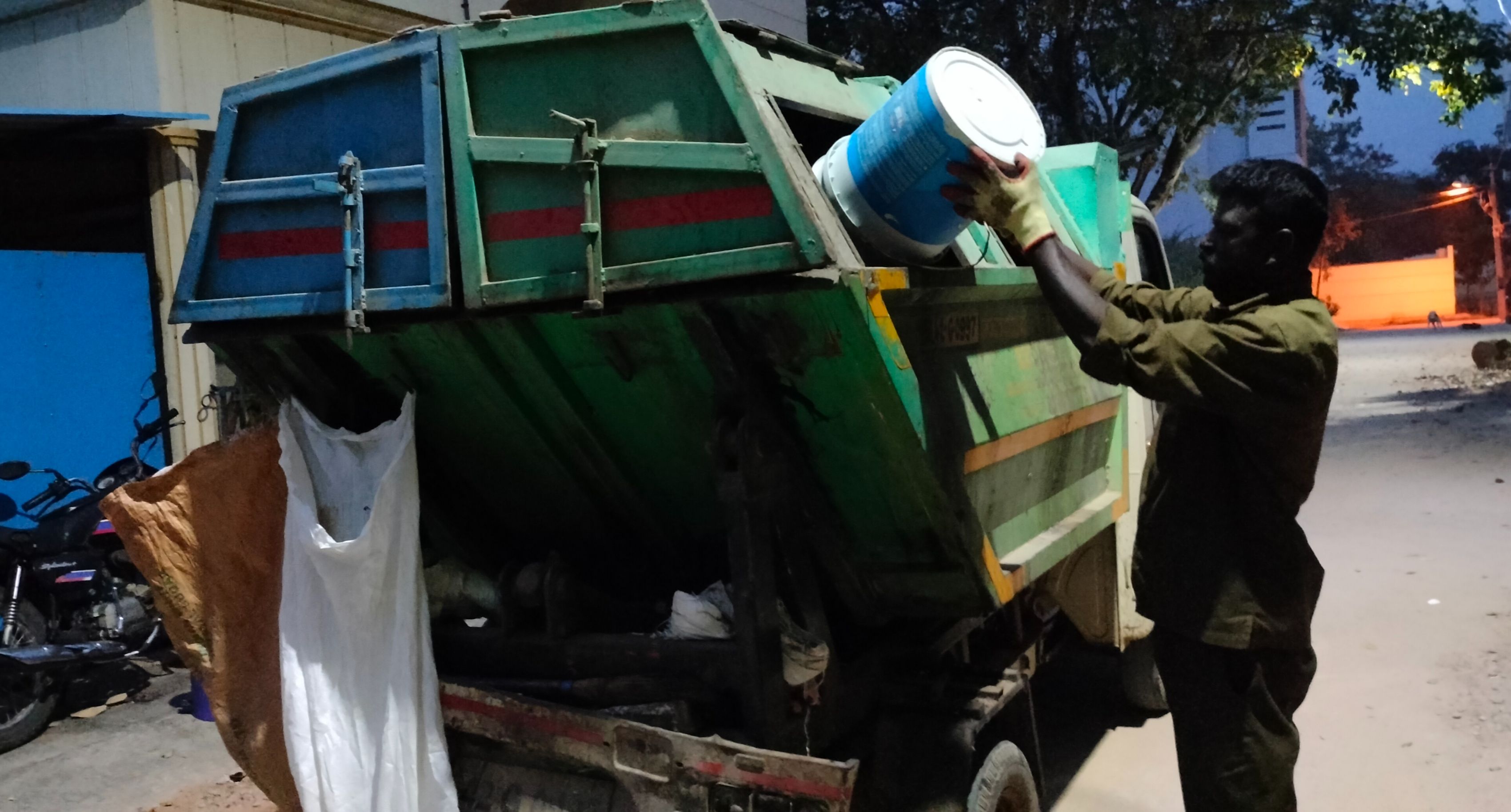 ಕನಕಪುರ ನಗರಸಭೆಯ ಪೌರ ಕಾರ್ಮಿಕರು ಮನೆಗಳಿಂದ ಕಸ ಸಂಗ್ರಹಿಸಿ ವಾಹನಕ್ಕೆ ಹಾಕುತ್ತಿರುವುದು