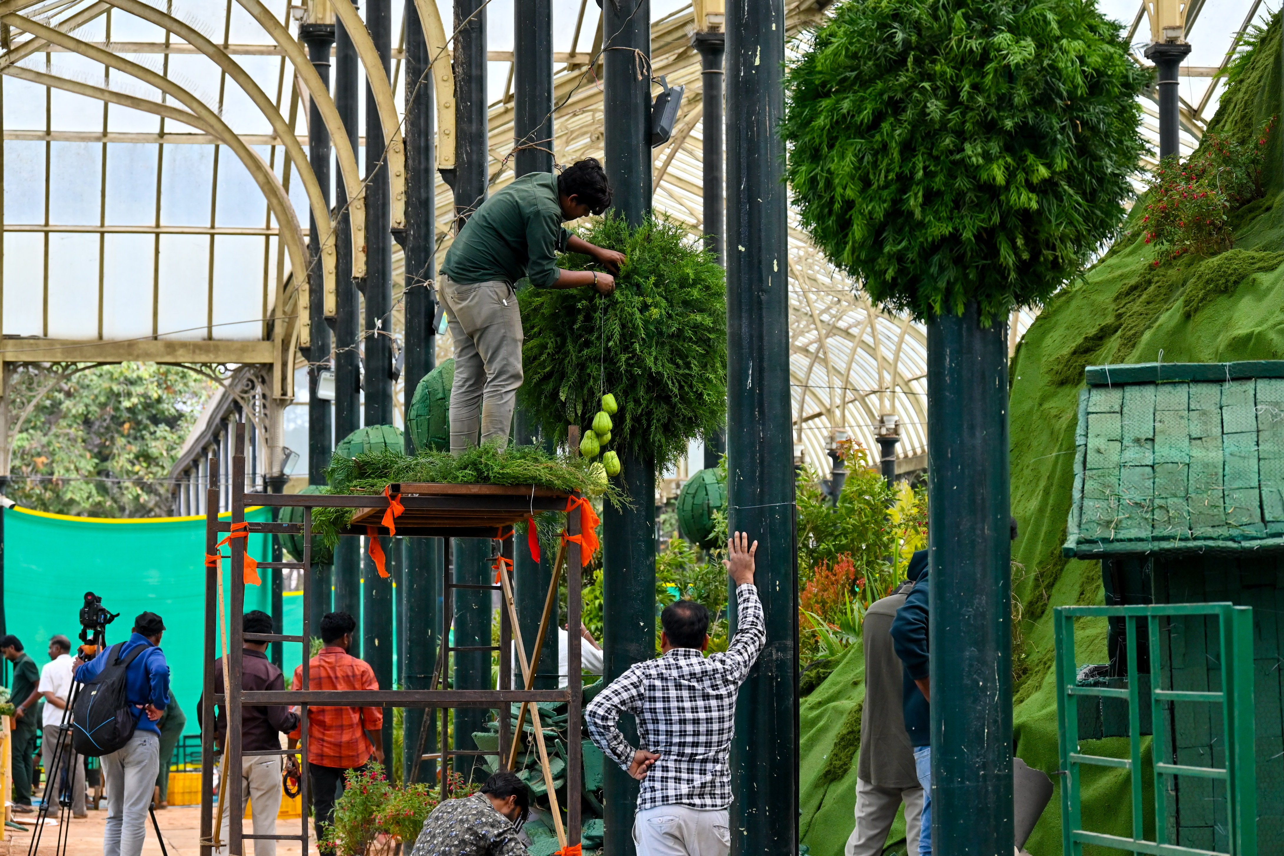 ಲಾಲ್‌ಬಾಗ್‌ನ ಗಾಜಿನ ಮನೆಯಲ್ಲಿ ನಡೆಯಲಿರುವ ಫಲಪುಷ್ಪ ಪ್ರದರ್ಶನದ ಸಿದ್ಧತೆಯಲ್ಲಿ ತೊಡಗಿರುವ ಕಾರ್ಮಿಕರು  