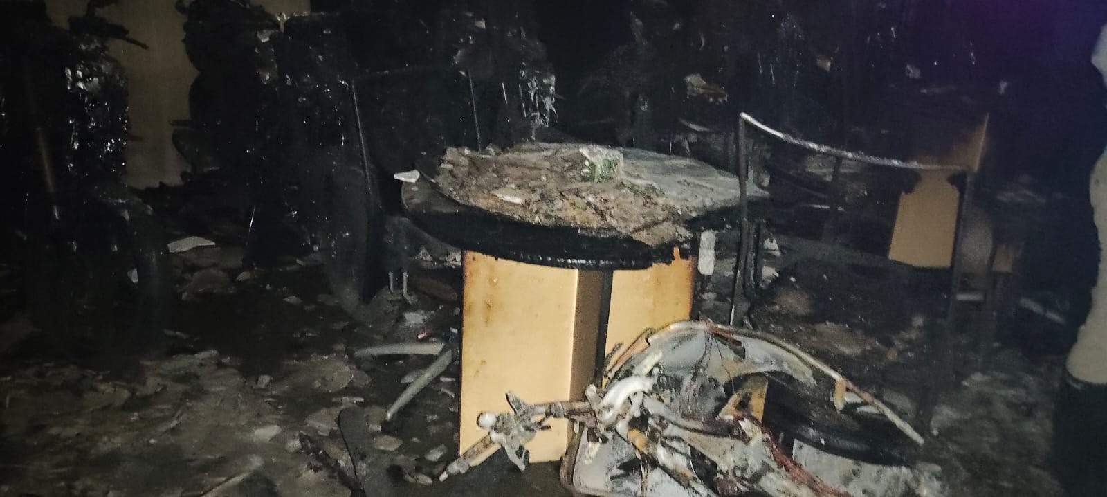 ಬೆಂಕಿ ಅವಘಡದಲ್ಲಿ ಭಸ್ಮವಾಗಿರುವ ಟೇಬಲ್ ಹಾಗೂ ಕಂಪ್ಯೂಟರ್  