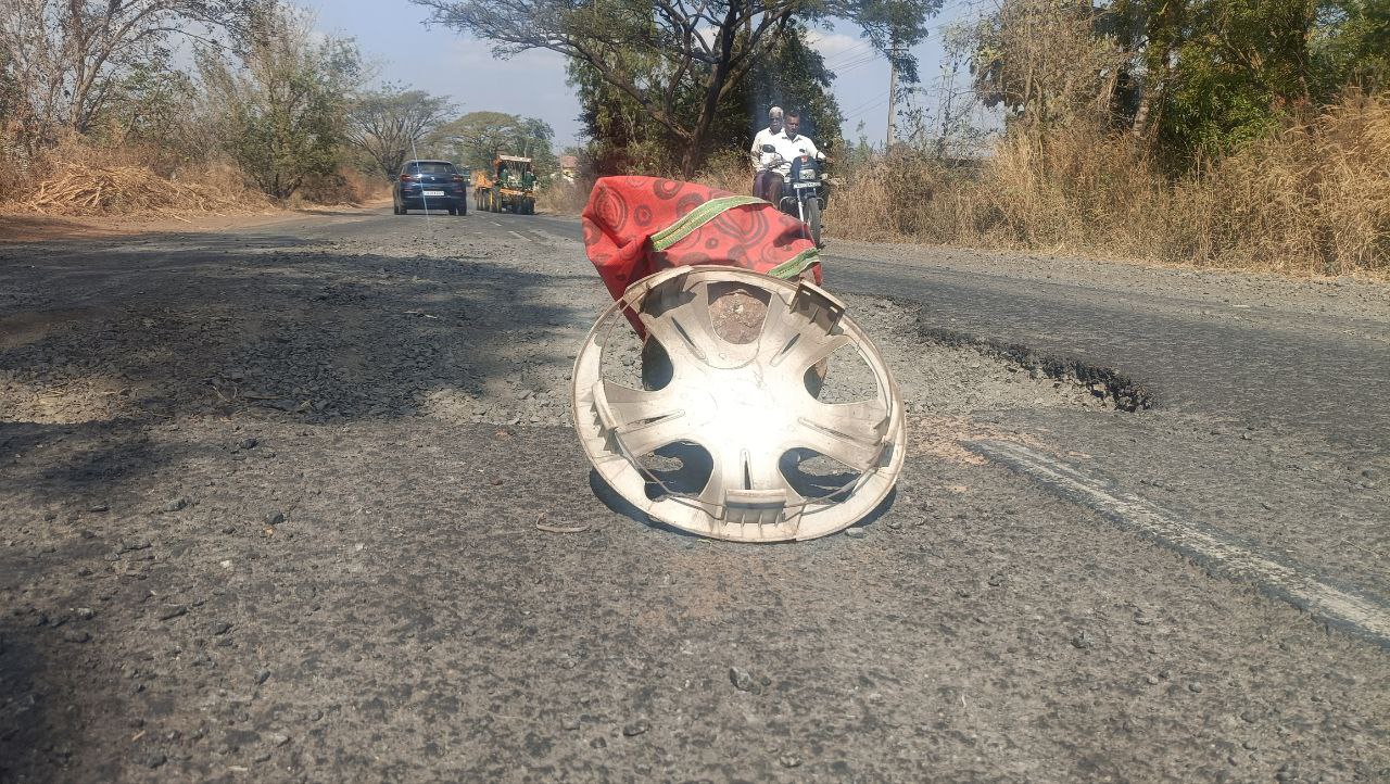 ಚಿಕ್ಕೋಡಿ– ಬೆಳಗಾವಿಯ ಪ್ರಮುಖ ರಸ್ತೆಯ ಅಮ್ಮನಬಾವಿ ಕ್ರಾಸ್ ಬಳಿಯಲ್ಲಿ ಗುಂಡಿ ಬಿದ್ದ ರಸ್ತೆಯ ಮೇಲೆ ಪ್ರಯಾಣಿಕರ ಜಾಗೃತಿಗಾಗಿ ಕಲ್ಲು ಇರಿಸಿ ಕೆಂಪು ವಸ್ತ್ರ ಹೊದಿಸಲಾಗಿದೆ