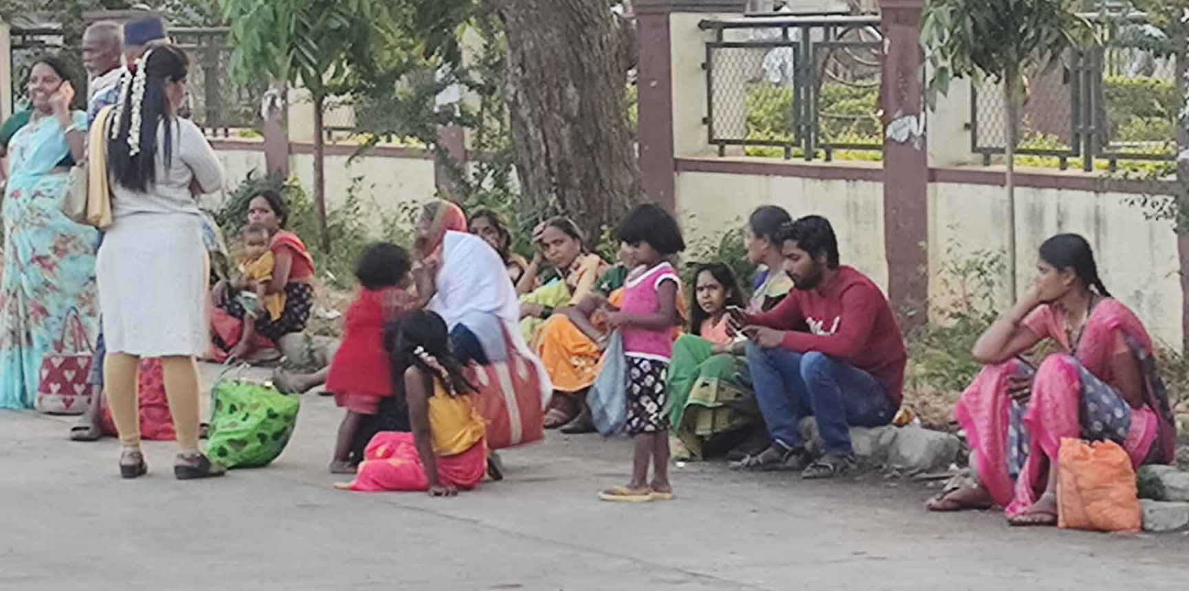 ಆಸನ ವ್ಯವಸ್ಥೆ ಇಲ್ಲದ ಕಾರಣ ಪ್ರಯಾಣಿಕರು ನೆಲದ ಮೇಲೆ ಕುಳಿತಿರುವುದು