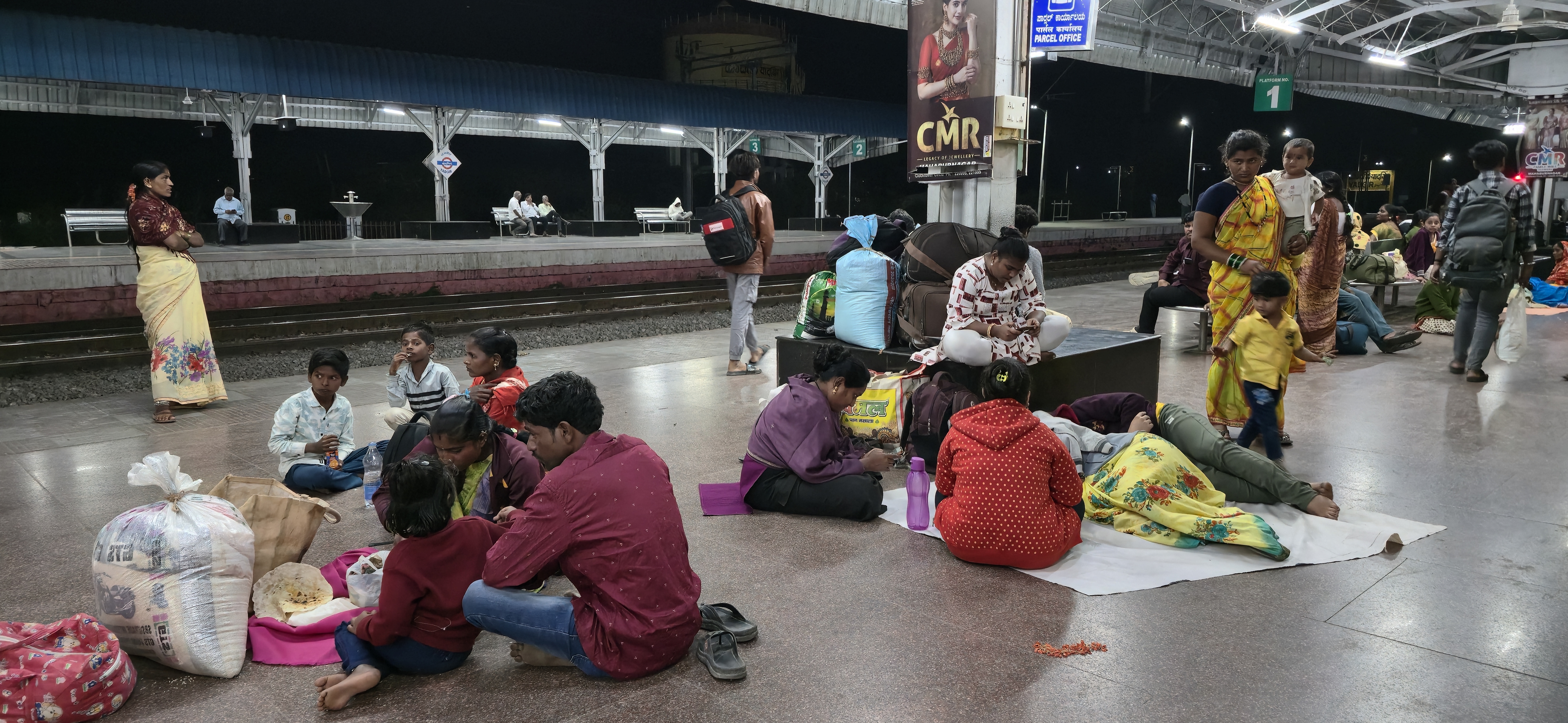 ರೈಲಿಗಾಗಿ ಕಾಯುತ್ತಿರುವ ಪ್ರಯಾಣಿಕರು