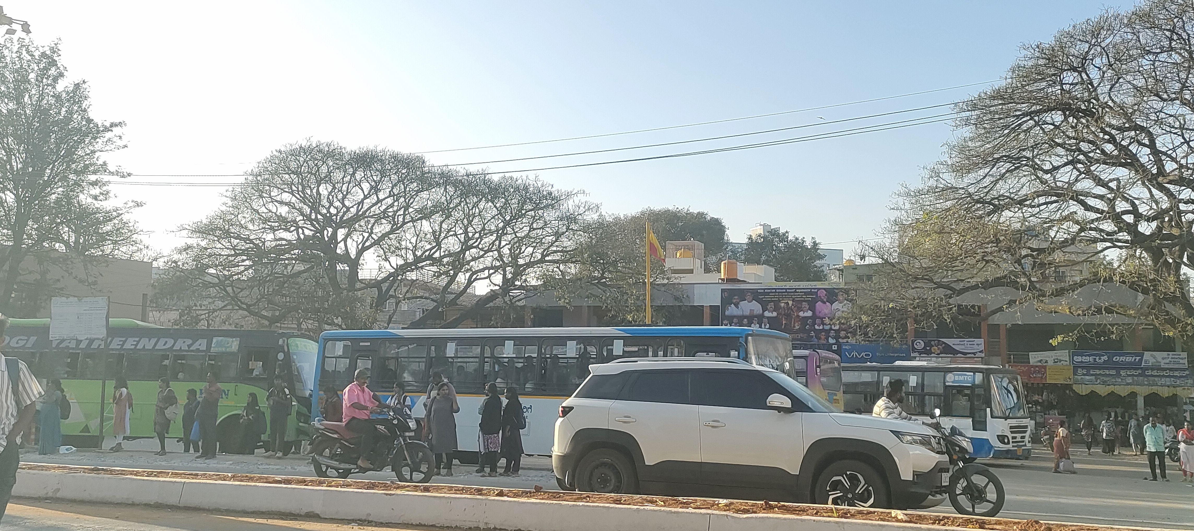 ದೇವನಹಳ್ಳಿ ಪಟ್ಟಣದ ಕೇಂದ್ರ ಸ್ಥಾನದಲ್ಲಿರುವ ಬಸ್ ನಿಲ್ದಾಣದಲ್ಲಿ ಸೂಕ್ತವಾಗಿ ತಂಗುದಾಣಗಳು ಇಲ್ಲದೇ ಇರುವುದು